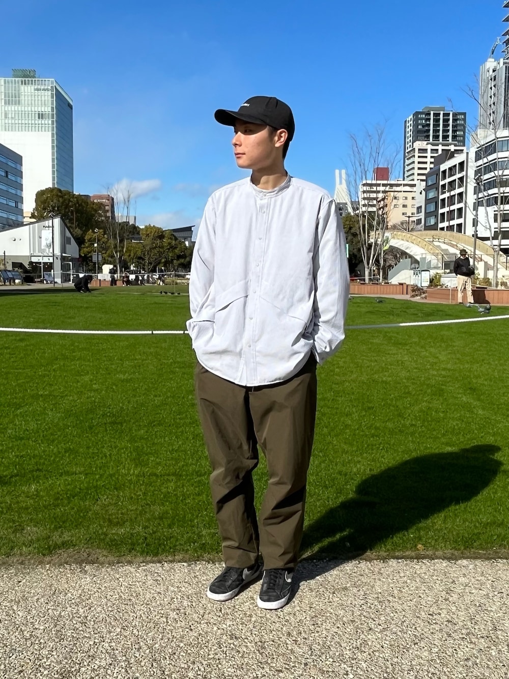 グレー系のシャツ/ブラウス、グリーン系のその他パンツ、ブラック系のキャップを着用したメンズの春コーディネートの1枚目の写真