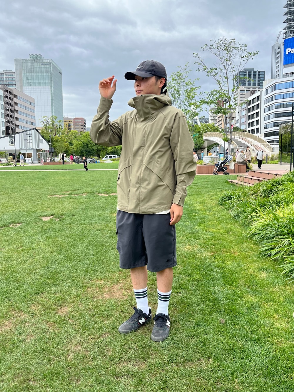 ブラック系のカーゴパンツ、ベージュ系のマウンテンパーカー、ホワイト系のTシャツ/カットソーを着用したメンズの春コーディネートの1枚目の写真