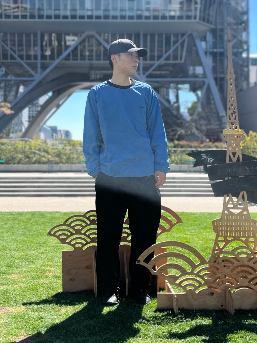 ブルー系のスウェット、ブラック系のキャップを着用したメンズの春コーディネートの1枚目の写真