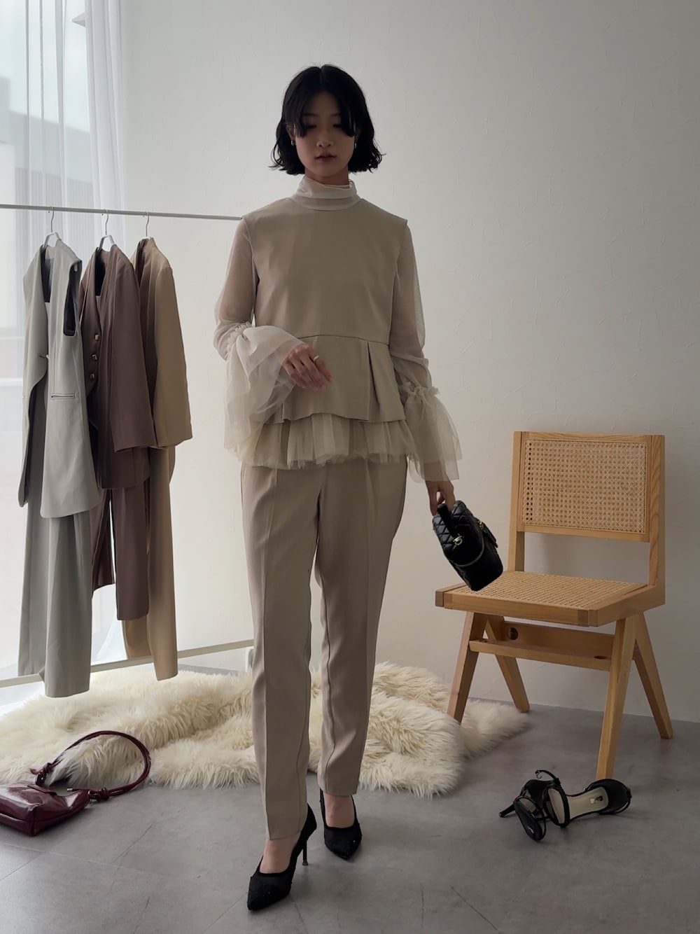 ベージュ系のパンツドレス、ホワイト系のシャツ/ブラウスを着用したレディースの冬コーディネートの1枚目の写真