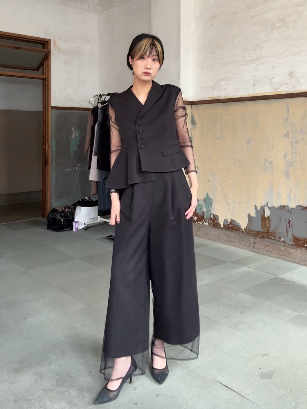 ブラック系のパンツドレスを着用したレディースの冬コーディネートの1枚目の写真