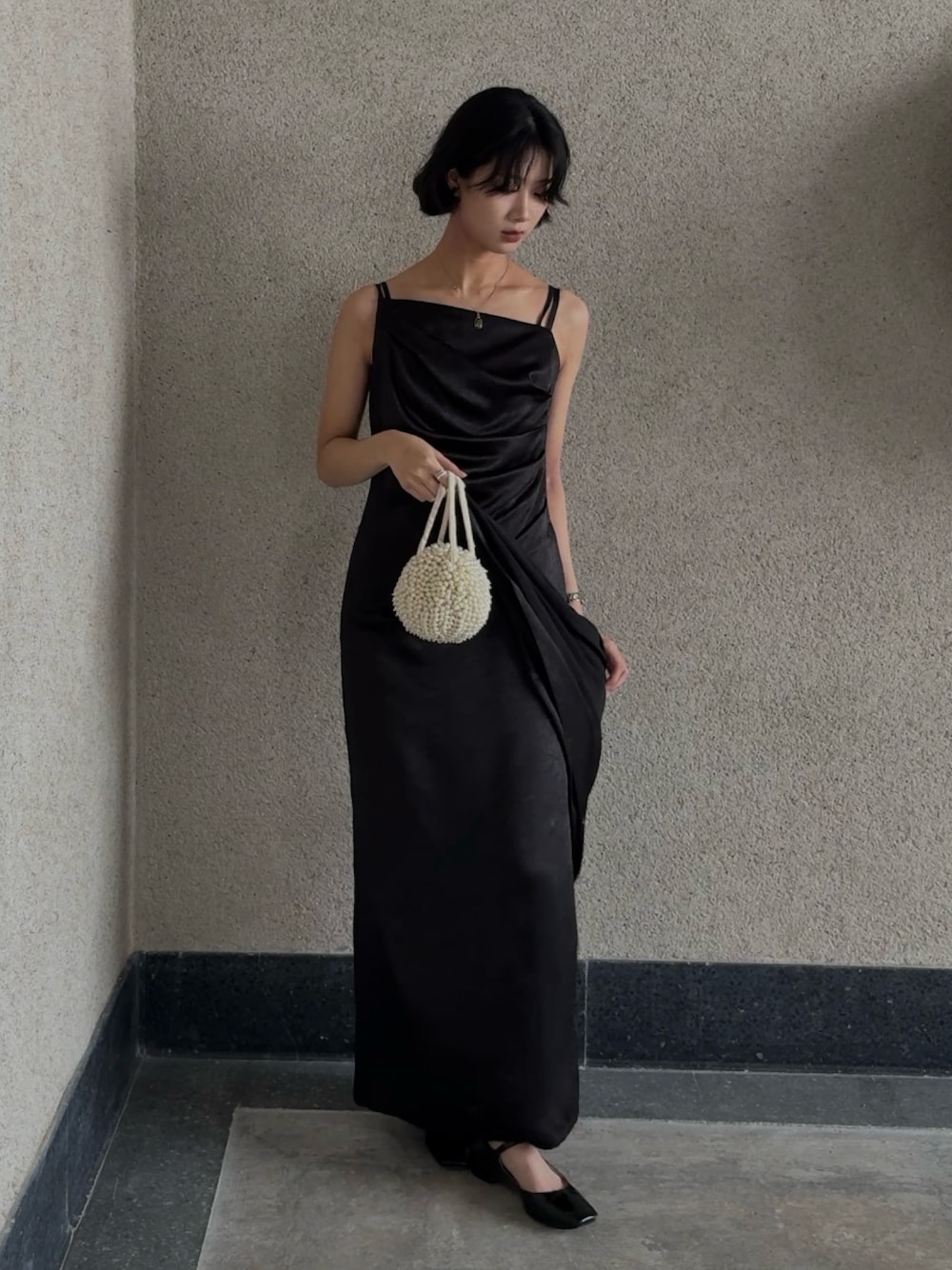 ブラック系のドレスを着用したレディースの春コーディネートの1枚目の写真