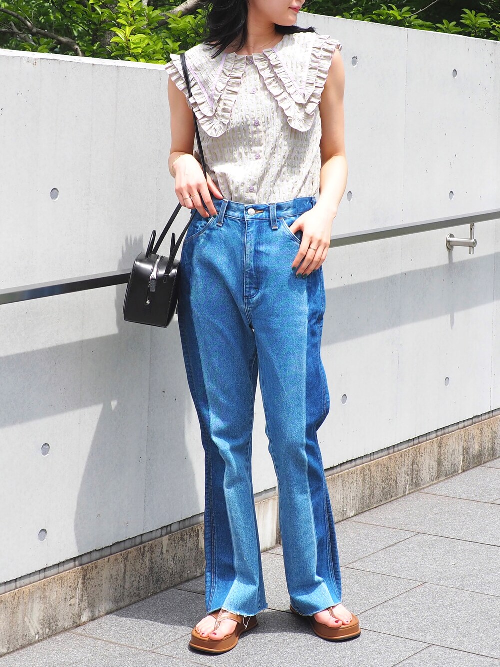 ブルー系のデニムパンツ、パープル系のシャツ/ブラウス、ブラウン系のサンダルを着用したレディースの春コーディネートの1枚目の写真