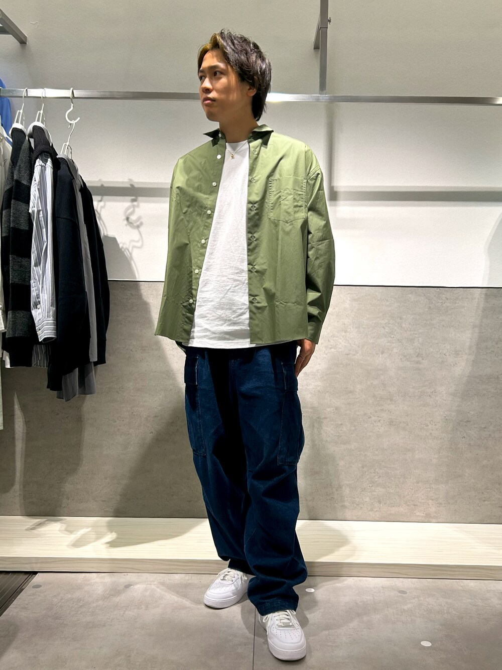 グリーン系のシャツ/ブラウス、ブルー系のカーゴパンツ、ホワイト系のスニーカーを着用したメンズの秋コーディネートの1枚目の写真