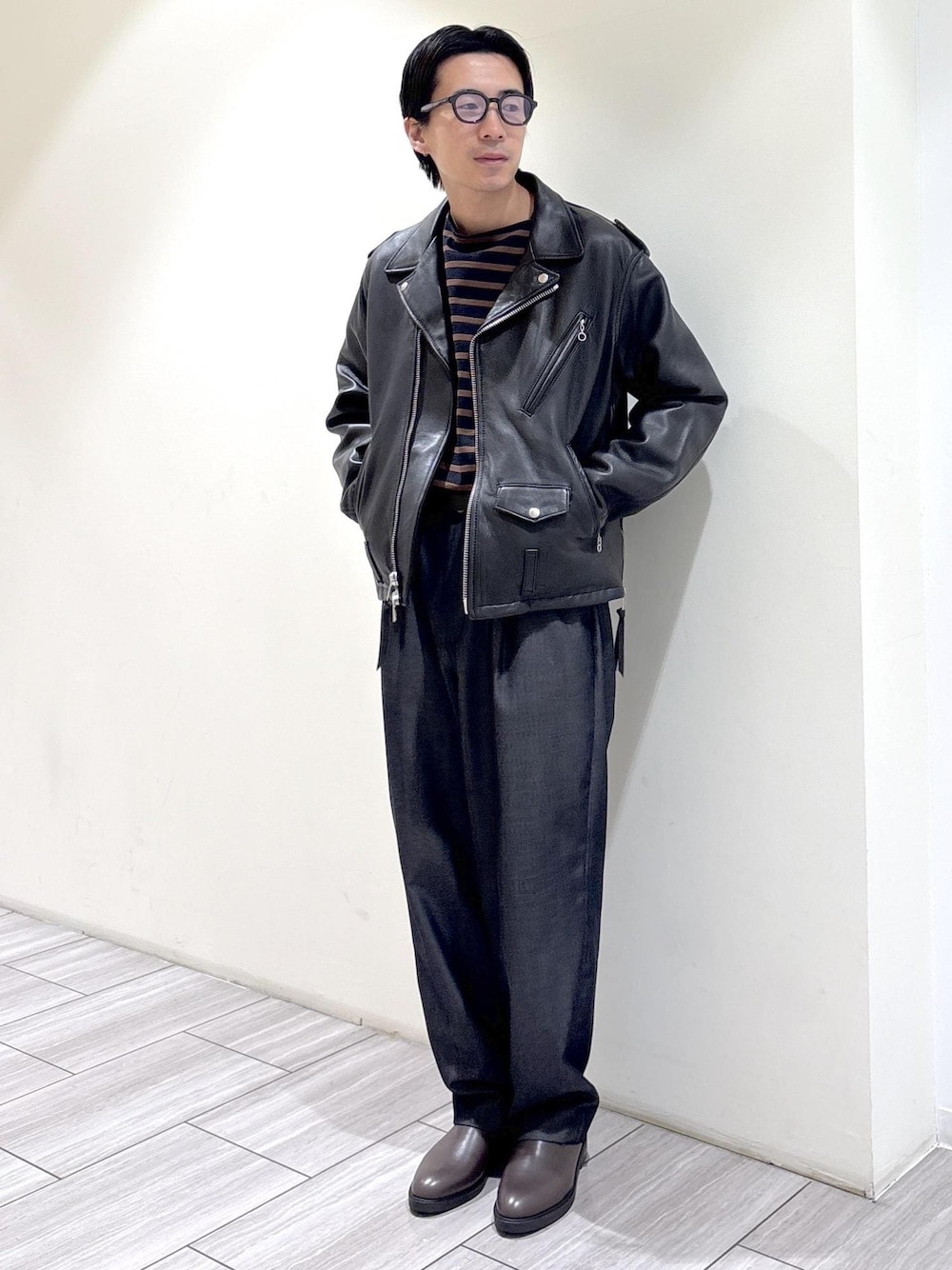 ブラック系のデニムパンツ、ブラウン系のTシャツ/カットソー、ブラック系のライダースジャケットを着用したメンズの秋コーディネートの1枚目の写真