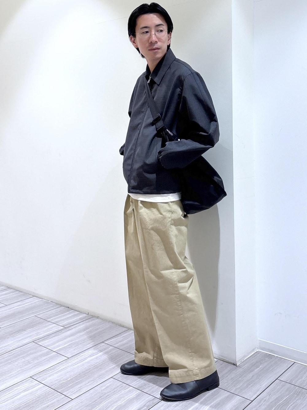 ブラック系のショルダーバッグ、グレー系のブルゾンを着用したメンズの春コーディネートの1枚目の写真