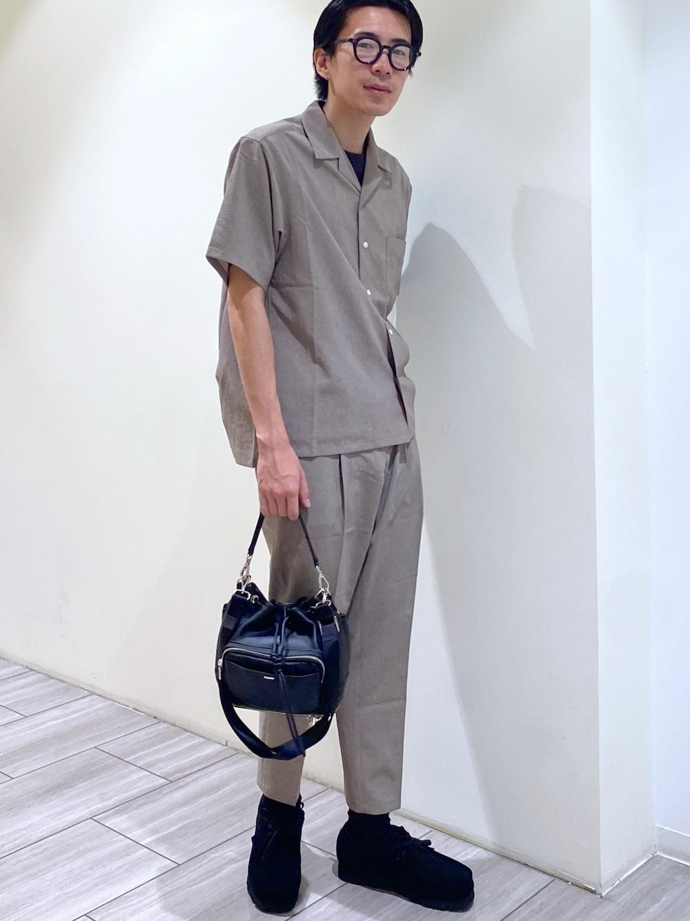 ベージュ系のセットアップ、ブラック系のTシャツ/カットソー、ブラック系のブーツを着用したメンズの夏コーディネートの1枚目の写真