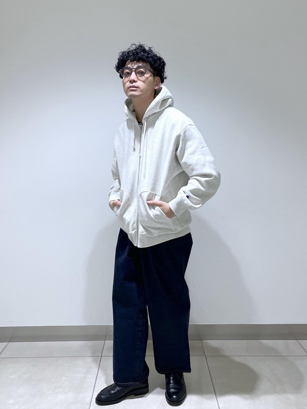 ホワイト系のパーカー、ブルー系のデニムパンツを着用したメンズの冬コーディネートの1枚目の写真