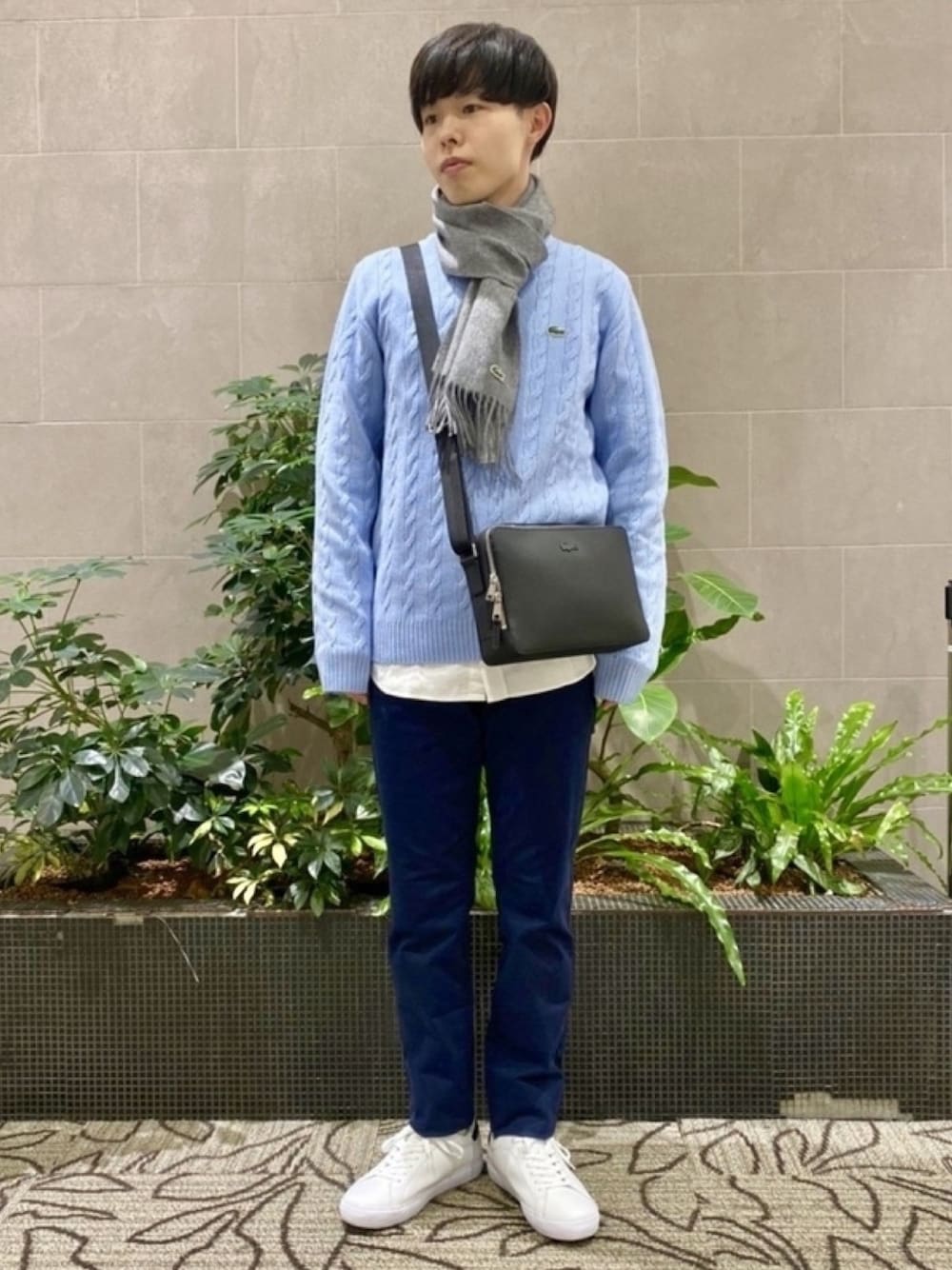 「メンズファッション、ニット、シャツ、チノパンツ、ショルダーバッグ、マフラー、スニーカー」｜「LACOSTEのケーブル編みニットセーター（ニット/セーター、ブルー系）」を使った、sakataさん（メンズ・169cm）の春コーディネートの1枚目の写真