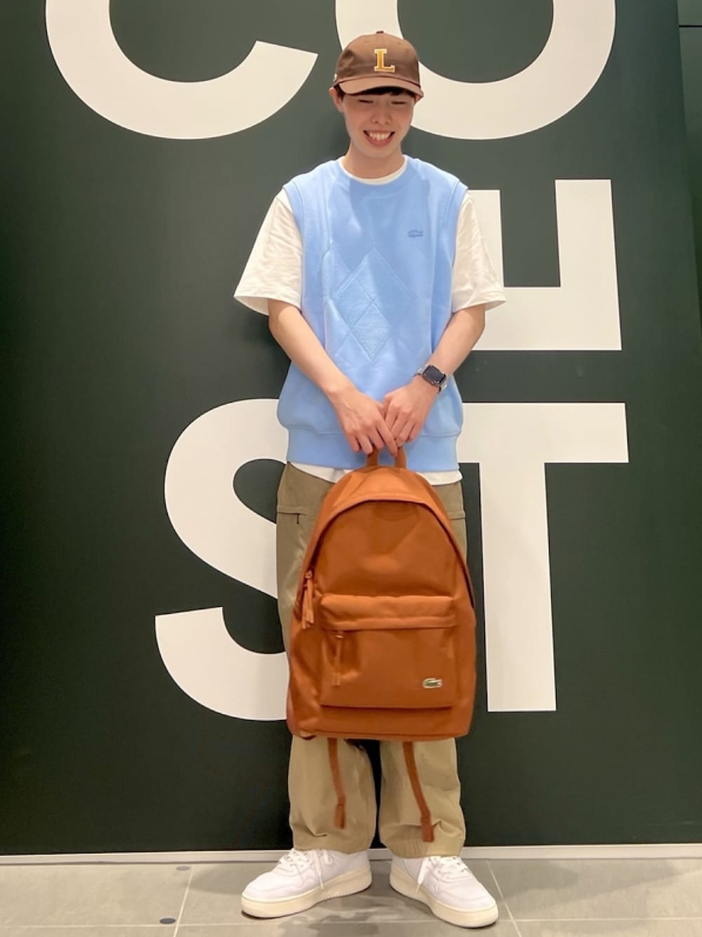 「春コーデ、春めき満開コーデ、メンズファッション、春服、トレンド、Tシャツ、ベスト、キャップ、カーゴパンツ、スニーカー、リュック、バックパック、ラコステ、LACOSTE」｜「LACOSTEのオーバーサイズ アーガイル柄パッチ&ステッチスウェットベスト（ベスト、ブルー系）」を使った、sakataさん（メンズ・169cm）の春コーディネートの1枚目の写真