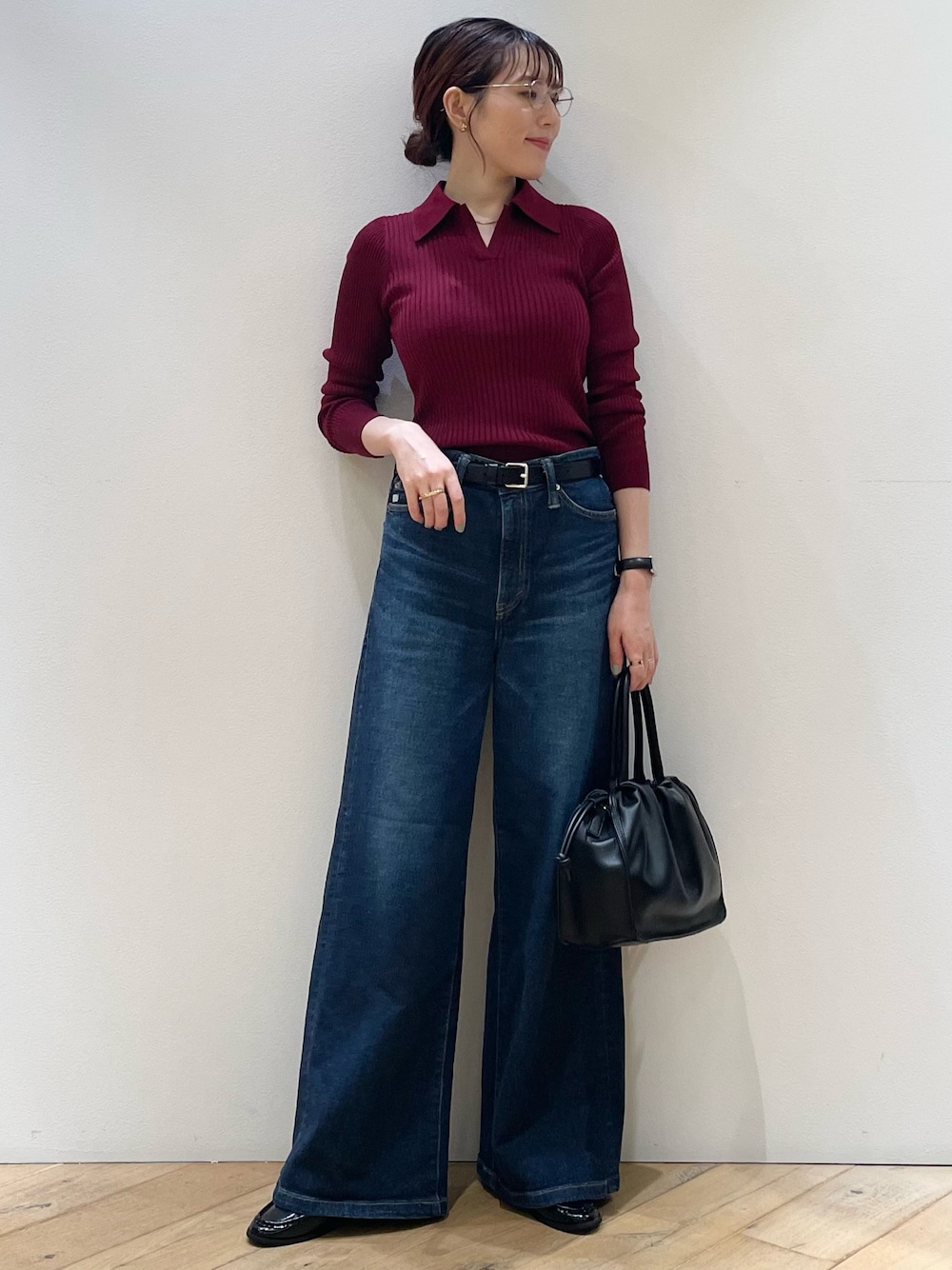 レッド系のニット/セーター、ブルー系のデニムパンツ、ブラック系のローファーを着用したレディースの秋コーディネートの1枚目の写真