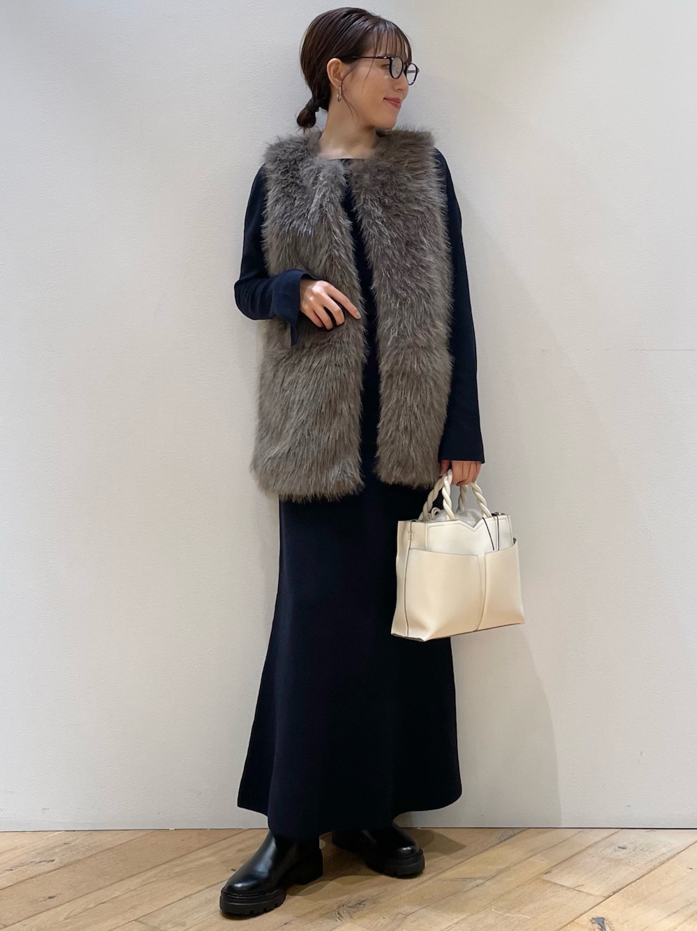 ブラウン系のベスト、ブルー系のニット/セーター、ブルー系のスカートを着用したレディースの秋コーディネートの1枚目の写真