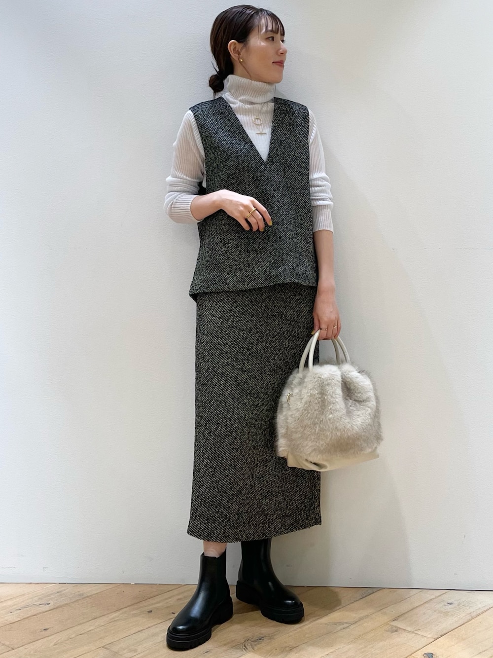 ブラック系のスカート、ブラック系のベスト、グレー系のニット/セーターを着用したレディースの秋コーディネートの1枚目の写真