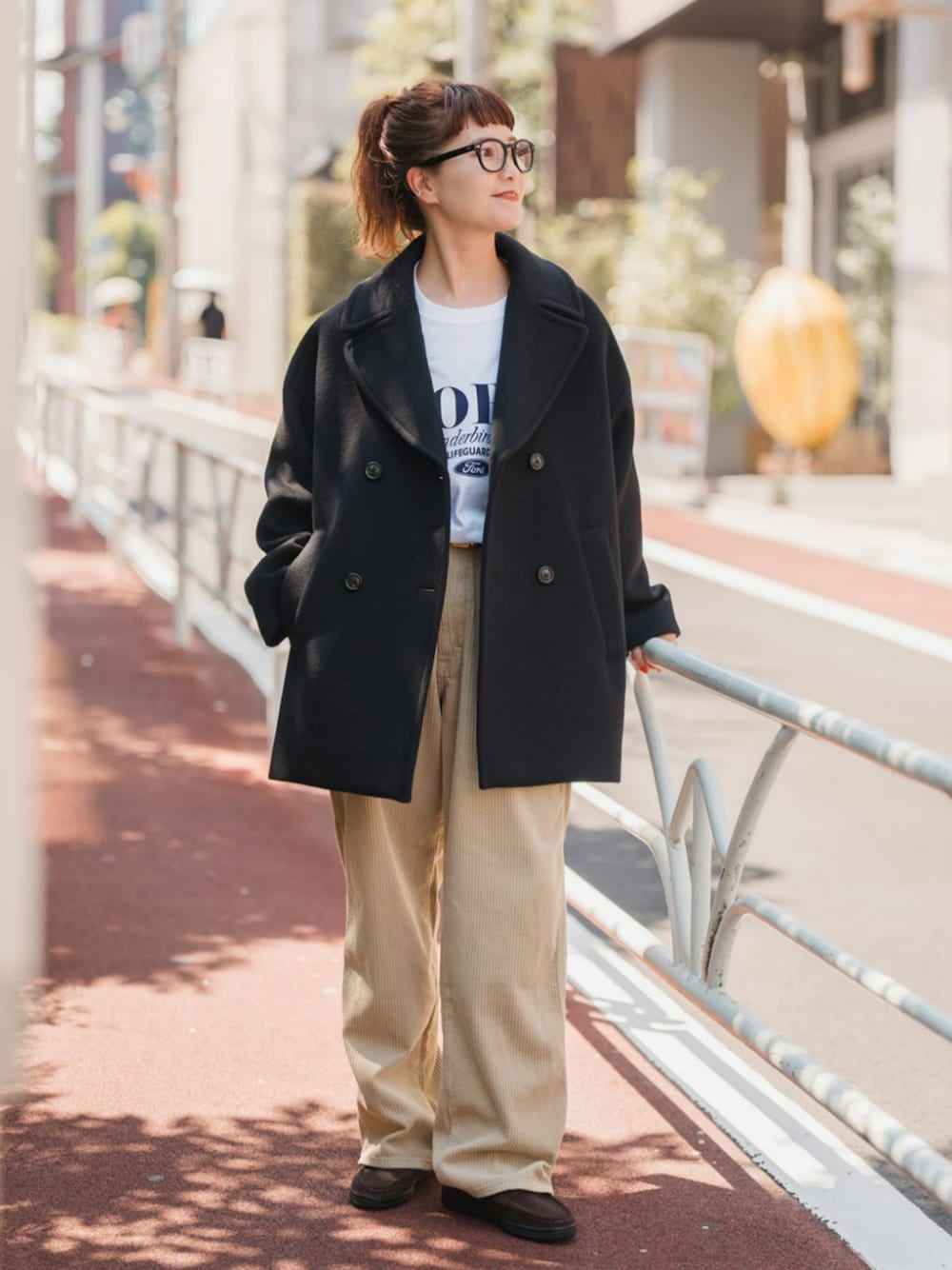 ブラウン系のスリッポン、ブラック系のピーコート、ホワイト系のTシャツ/カットソーを着用したレディースの秋コーディネートの1枚目の写真