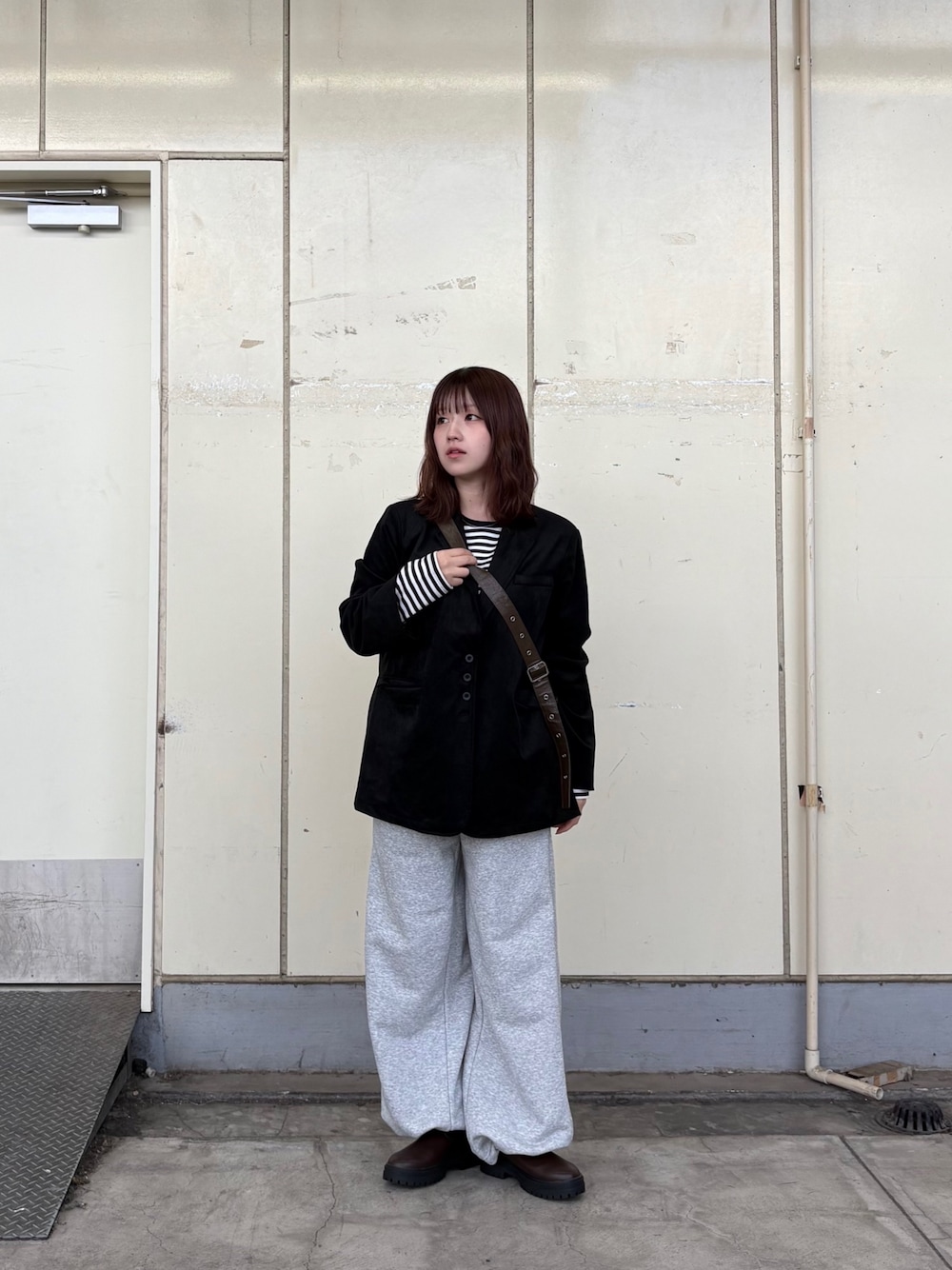 グレー系のその他パンツ、ホワイト系のTシャツ/カットソー、ブラック系のその他アウターを着用したレディースの秋コーディネートの1枚目の写真