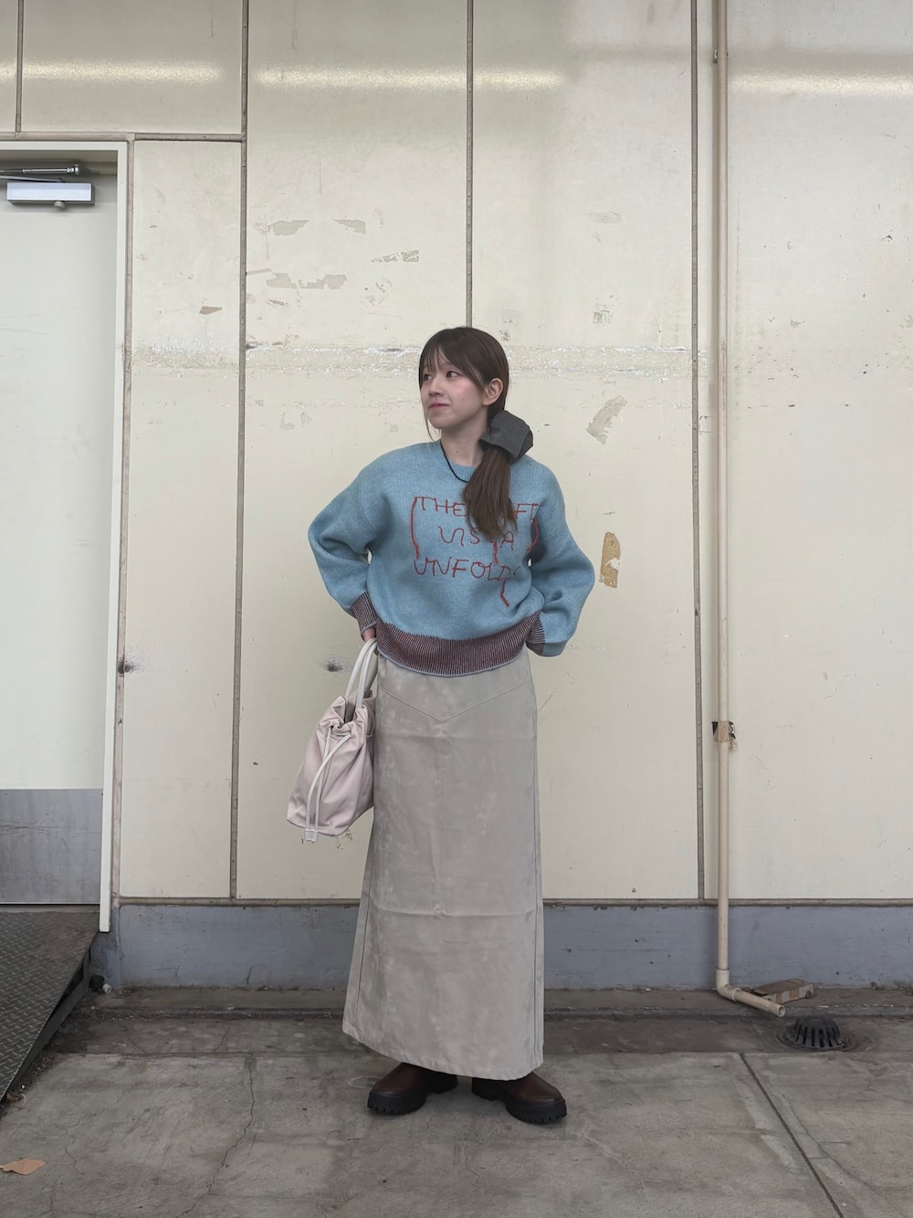 ブルー系のニット/セーター、ブラウン系のブーツ、ベージュ系のスカートを着用したレディースの秋コーディネートの1枚目の写真