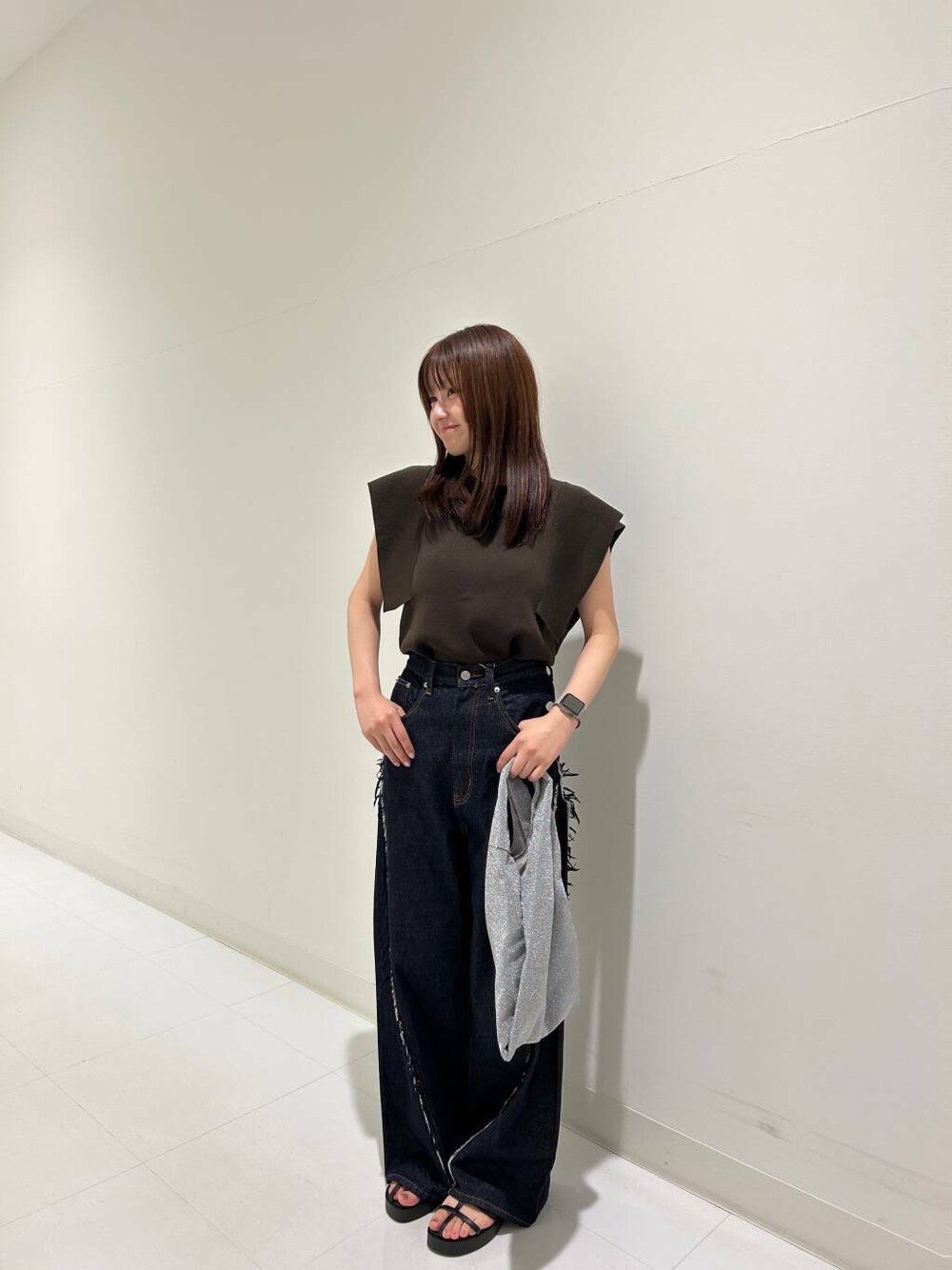 ブルー系のデニムパンツ、ブラック系のサンダル、ブラウン系のニット/セーターを着用したレディースの夏コーディネートの1枚目の写真