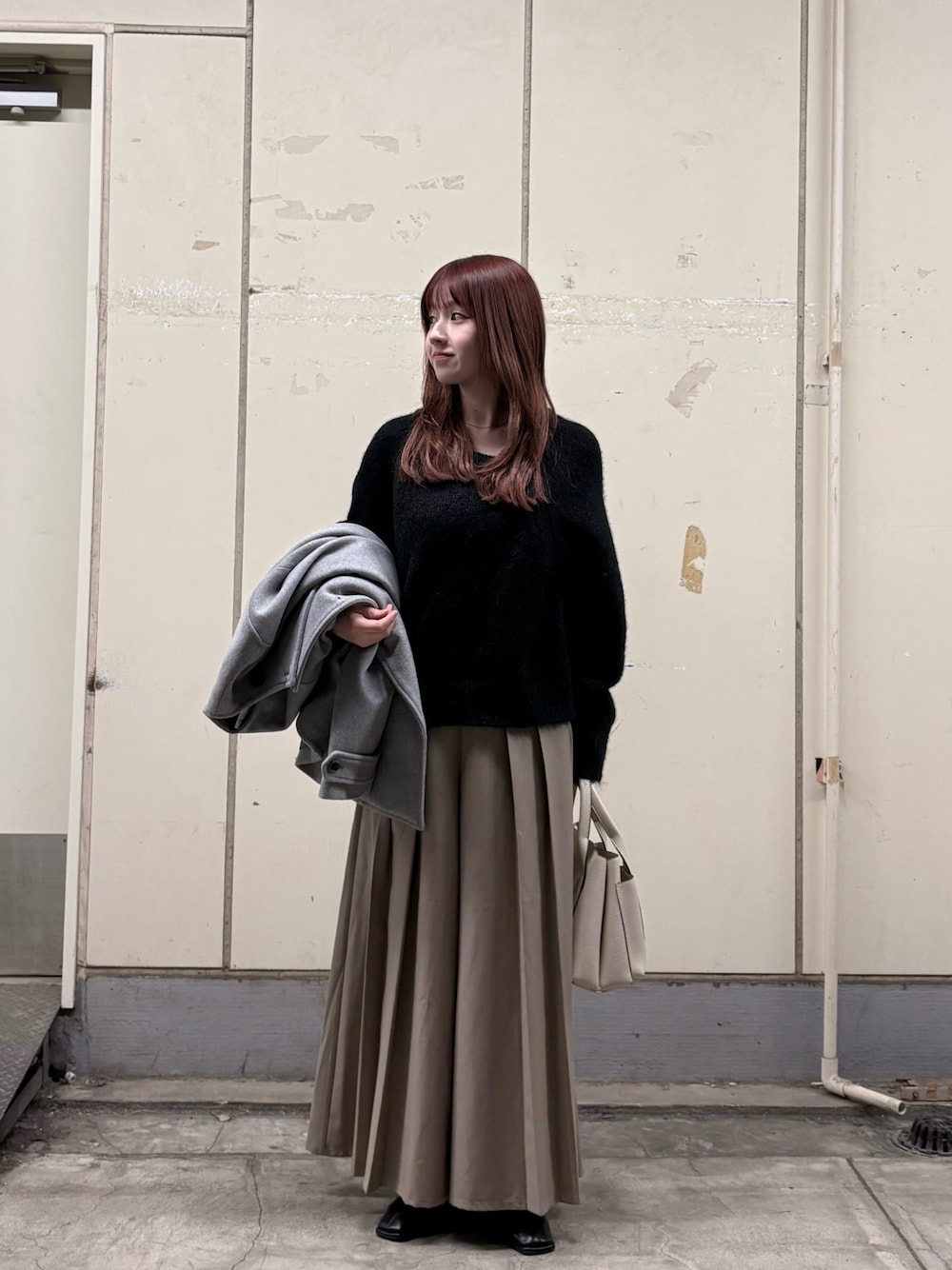 ブラック系のニット/セーター、ベージュ系のその他パンツ、ホワイト系のトートバッグを着用したレディースの冬コーディネートの1枚目の写真