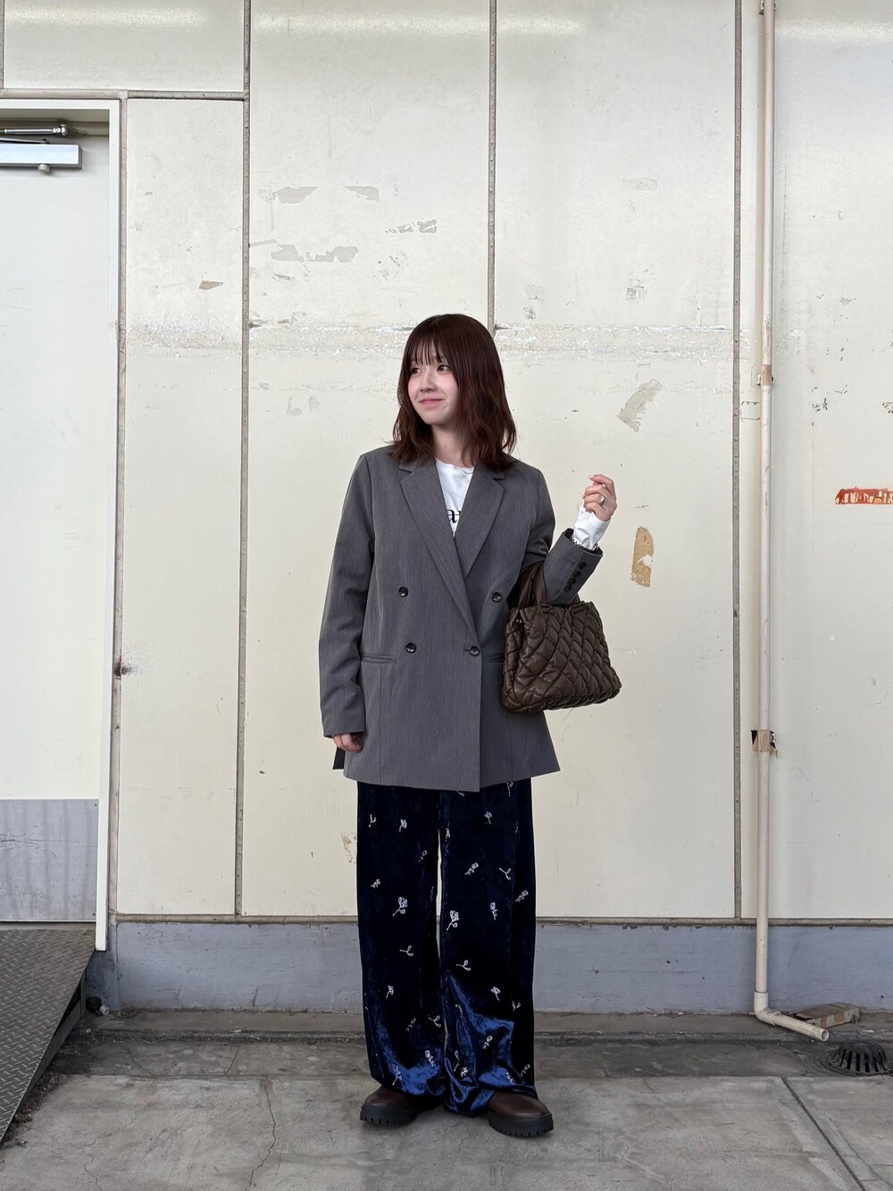ホワイト系のTシャツ/カットソー、グレー系のその他アウター、ブラウン系のハンドバッグを着用したレディースの秋コーディネートの1枚目の写真