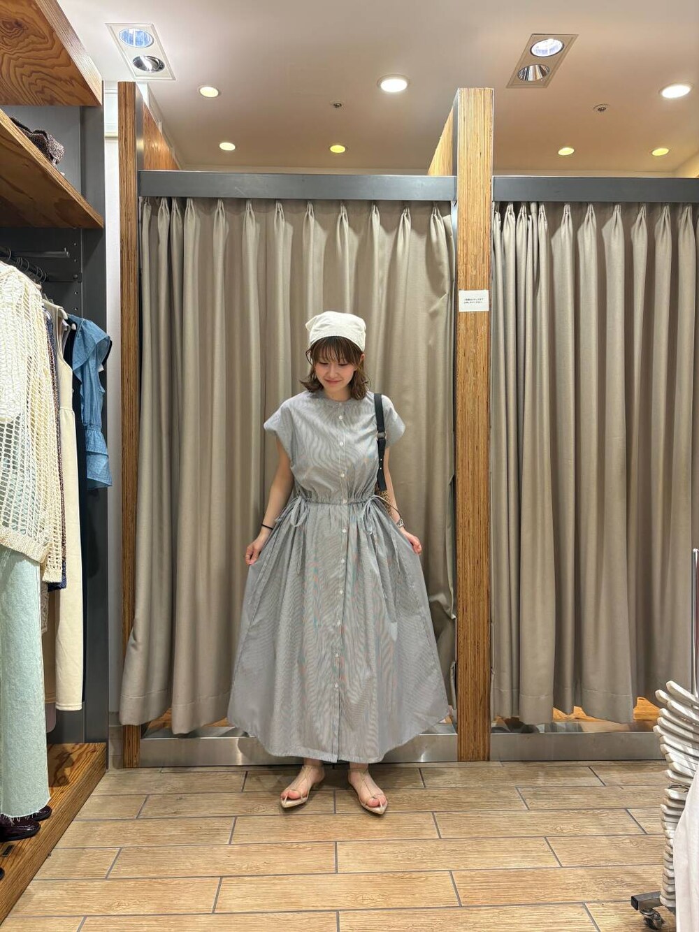 イエロー系のトートバッグ、ベージュ系のサンダル、ブラック系のワンピースを着用したレディースの春コーディネートの1枚目の写真