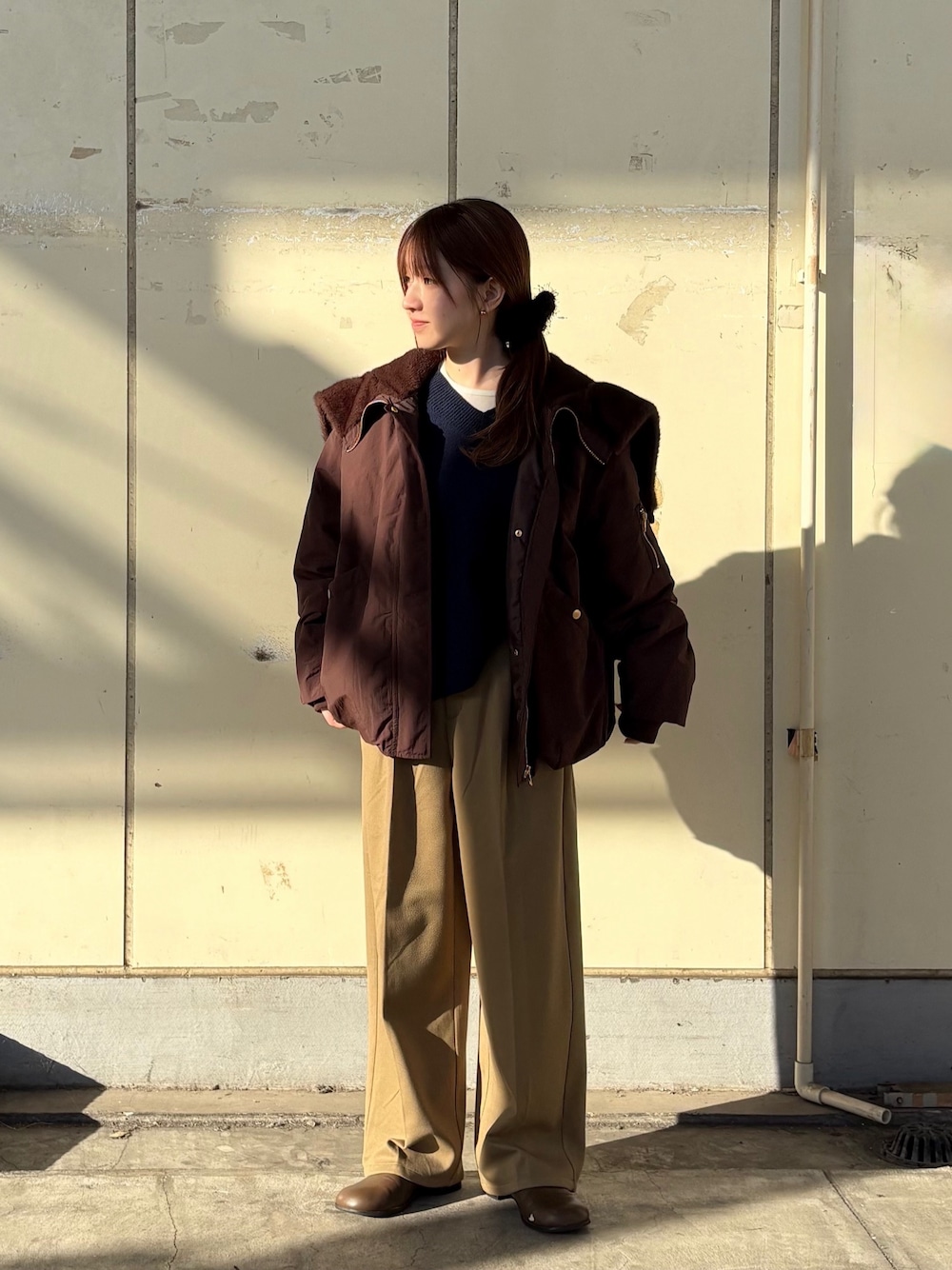 ブラウン系のブルゾン、ブルー系のニット/セーター、ベージュ系のその他パンツを着用したレディースの冬コーディネートの1枚目の写真