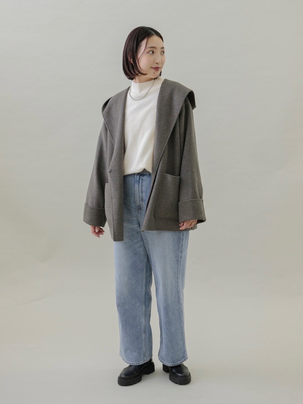 ブルー系のデニムパンツ、ブラック系のブーツ、グレー系のその他アウターを着用したレディースの秋コーディネートの1枚目の写真