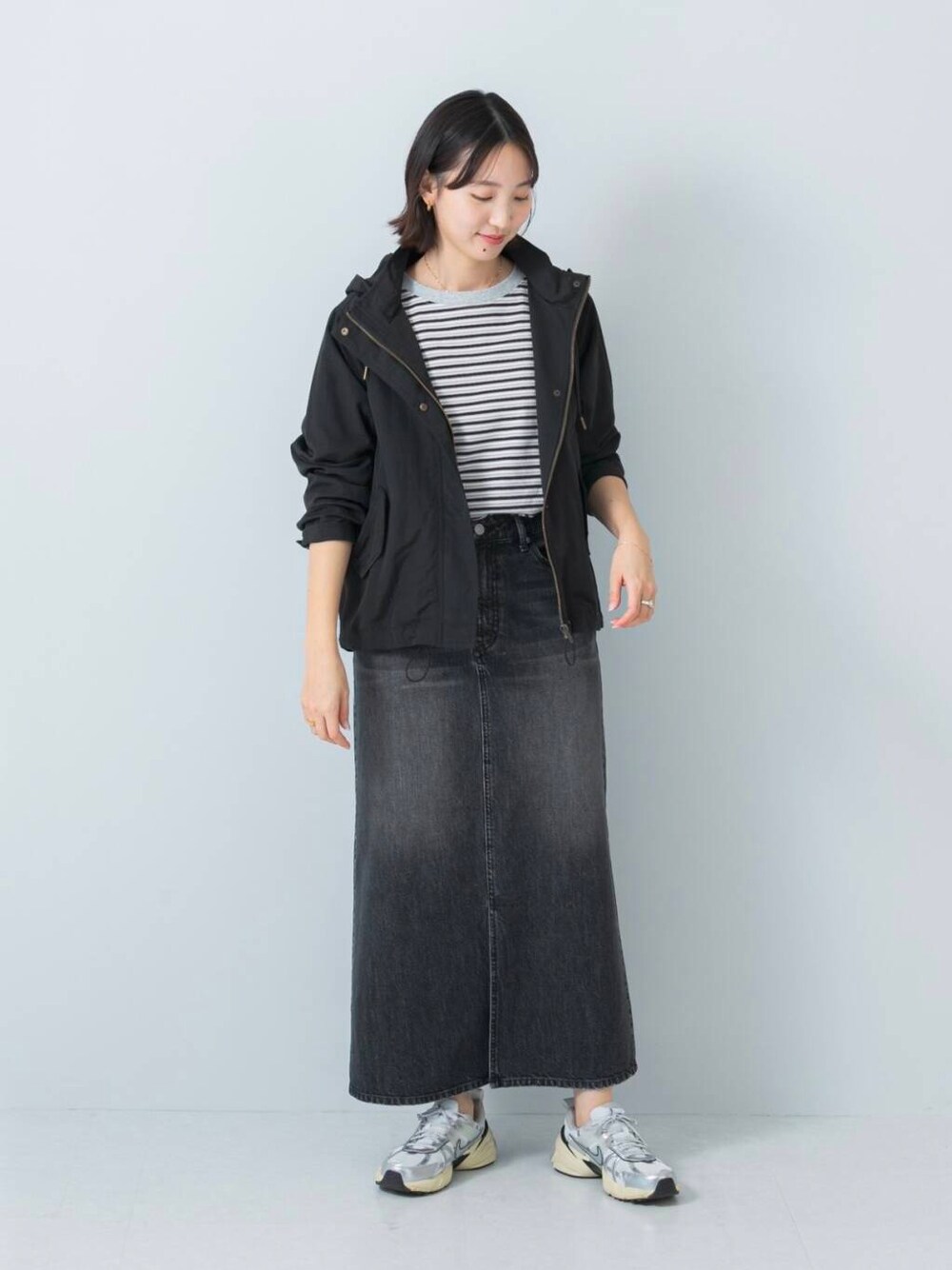 ブラック系のマウンテンパーカー、ブラック系のTシャツ/カットソー、ブラック系のスカートを着用したレディースの冬コーディネートの1枚目の写真