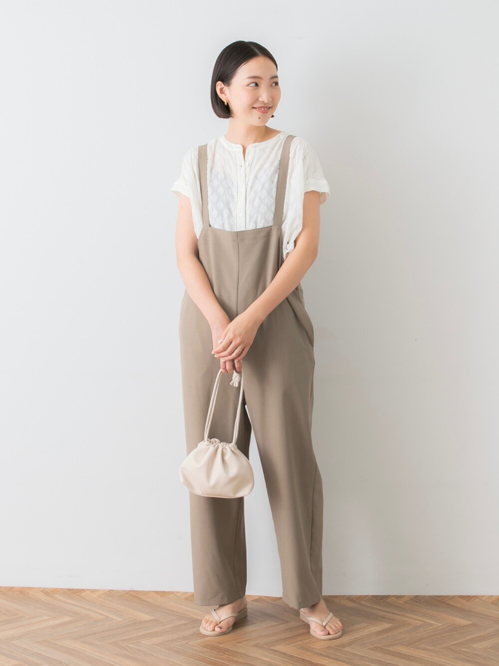 ホワイト系のシャツ/ブラウス、ベージュ系のサロペット/オーバーオール、ベージュ系のサンダルを着用したレディースの夏コーディネートの1枚目の写真