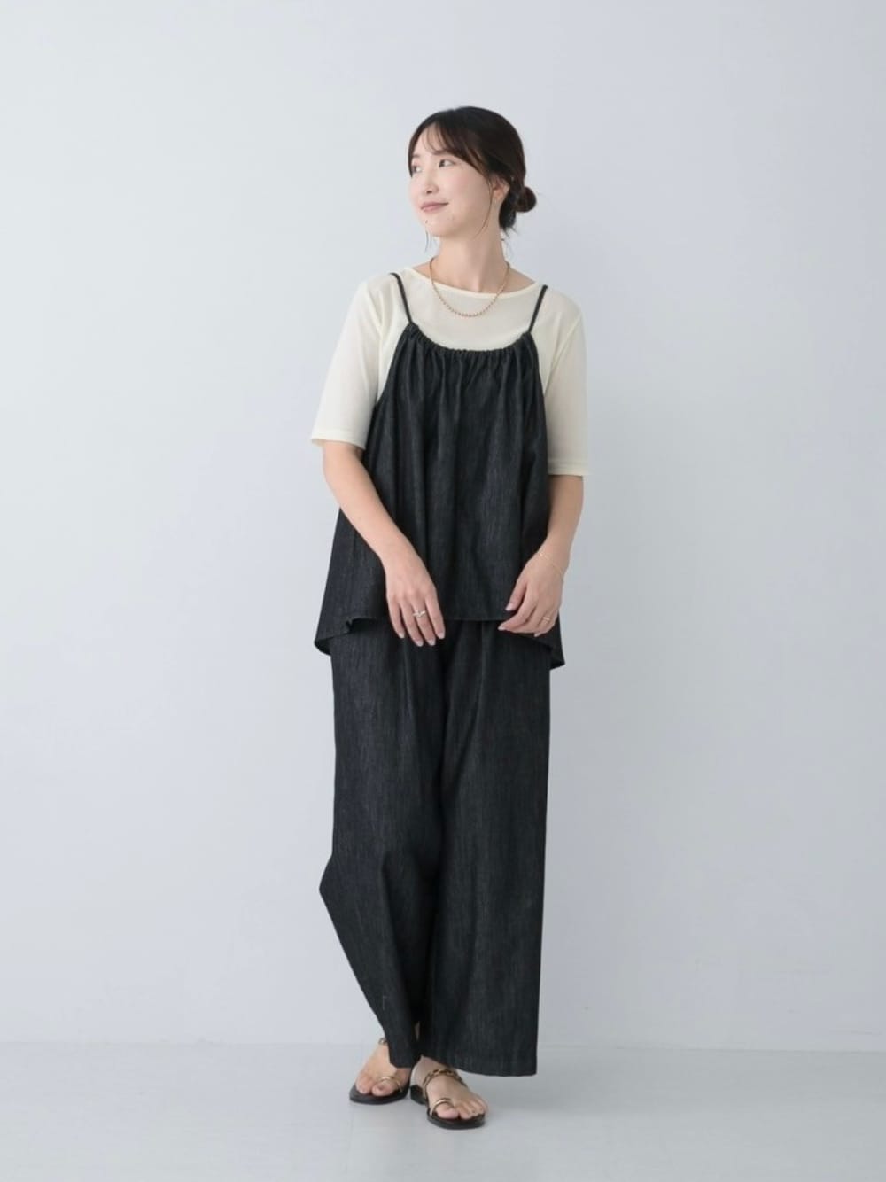 ブラック系のサロペット/オーバーオール、ホワイト系のTシャツ/カットソー、ゴールド系のネックレスを着用したレディースの夏コーディネートの1枚目の写真