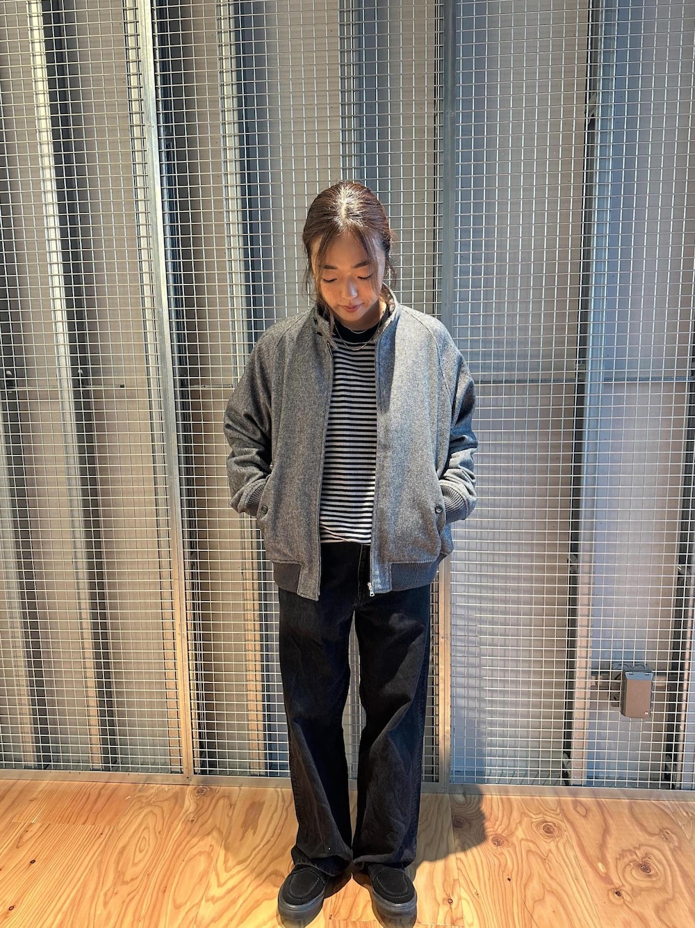 ブラック系のデニムパンツ、グレー系のブルゾンを着用したレディースの秋コーディネートの1枚目の写真
