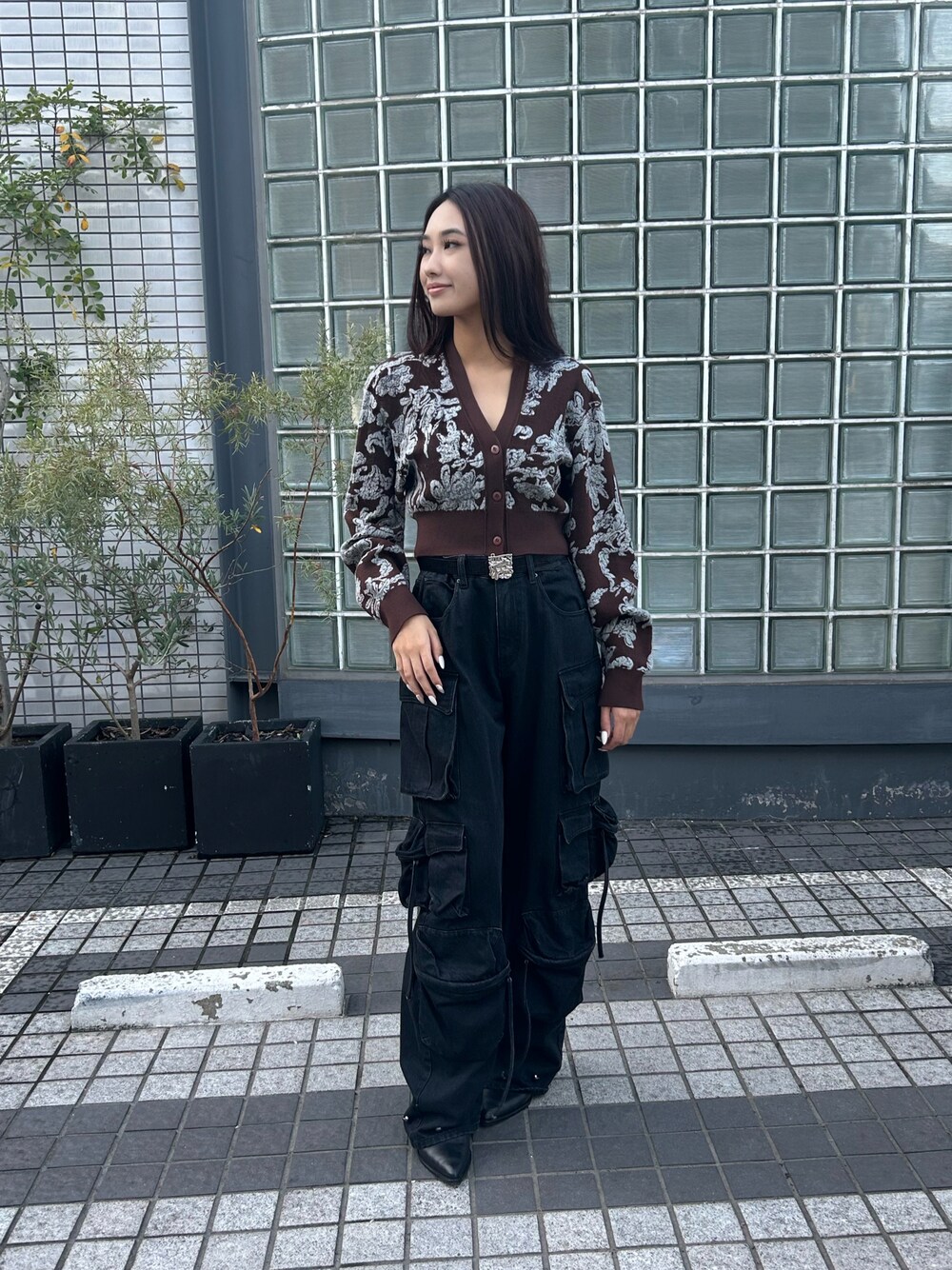 ブラウン系のニット/セーター、ブラック系のデニムパンツ、ブラック系のベルトを着用したレディースの秋コーディネートの1枚目の写真