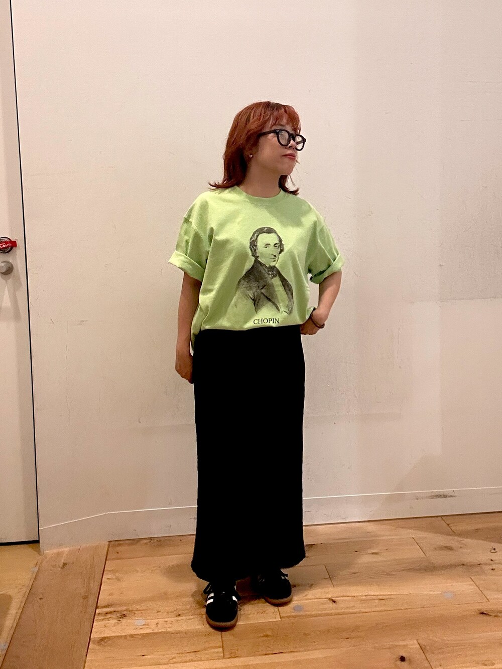 グリーン系のTシャツ/カットソー、ブラック系のスカートを着用したレディースの夏コーディネートの1枚目の写真