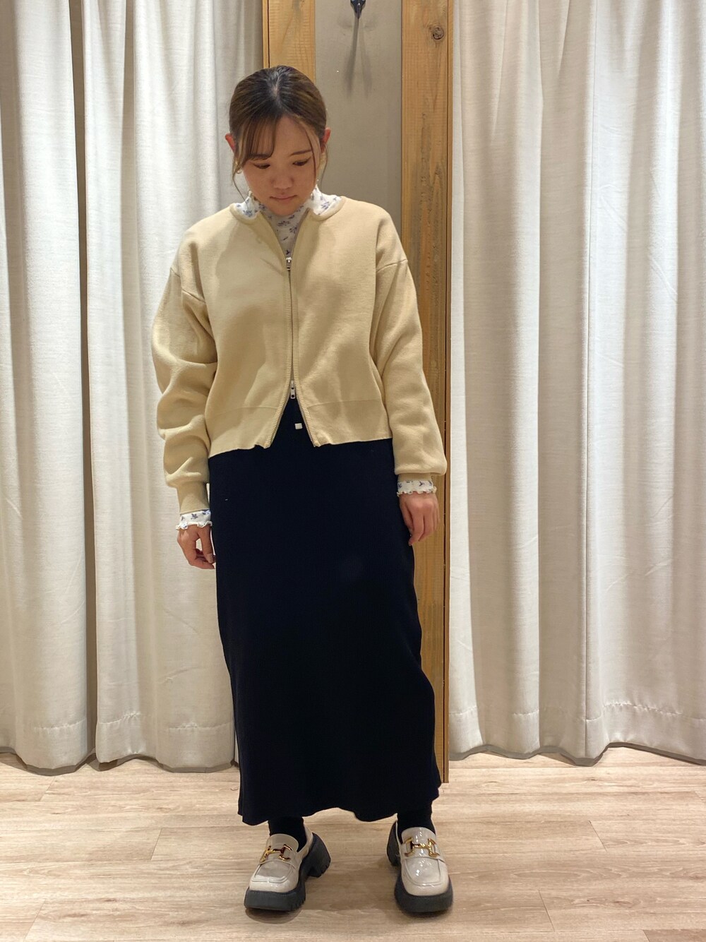 ベージュ系のカーディガン/ボレロ、パープル系のTシャツ/カットソー、ブラック系のスカートを着用したレディースの春コーディネートの1枚目の写真