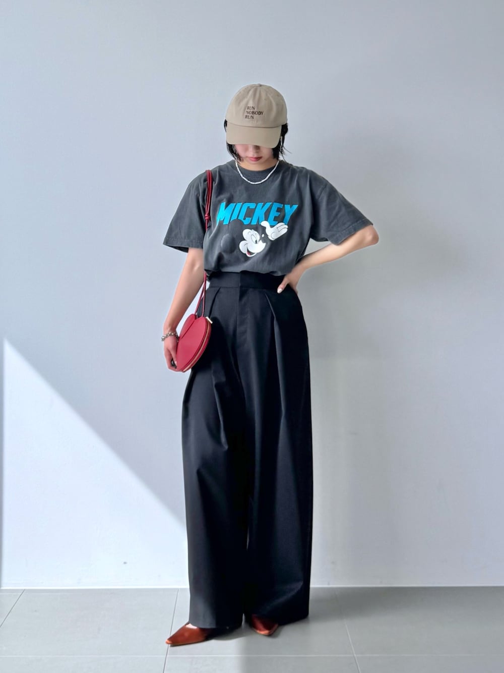 グレー系のTシャツ/カットソー、レッド系のショルダーバッグ、ブラウン系のパンプスを着用したレディースの春コーディネートの1枚目の写真