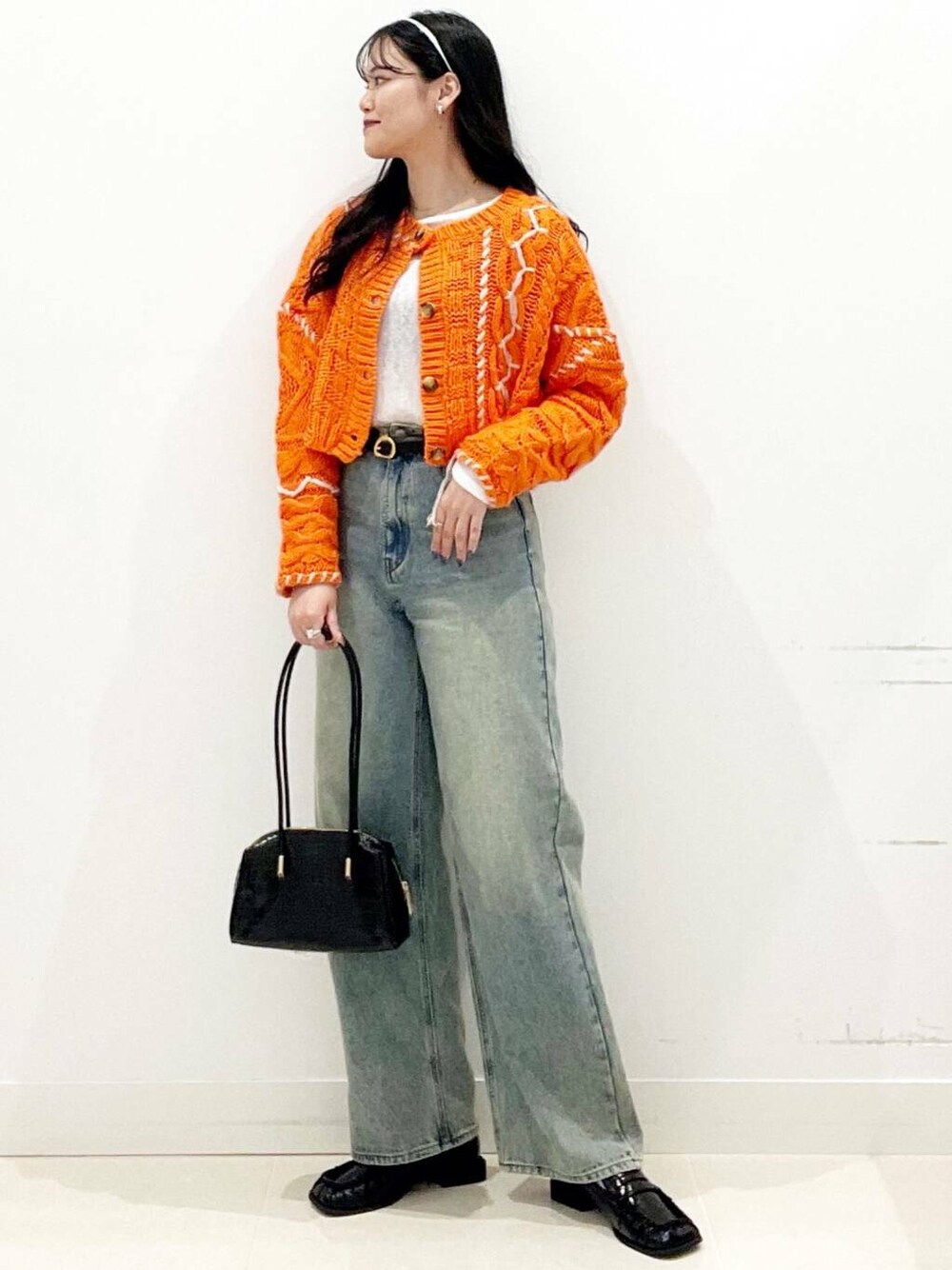 ブラック系のローファー、オレンジ系のカーディガン/ボレロ、ホワイト系のTシャツ/カットソーを着用したレディースの秋コーディネートの1枚目の写真