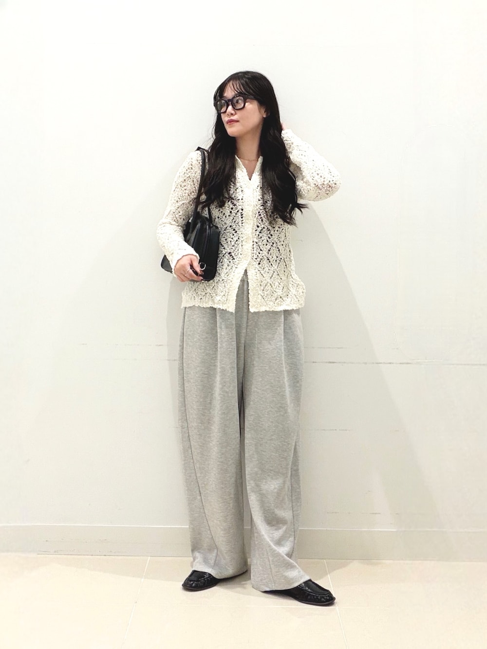 グレー系のその他パンツ、ホワイト系のニット/セーター、ブラック系のボストンバッグを着用したレディースの秋コーディネートの1枚目の写真