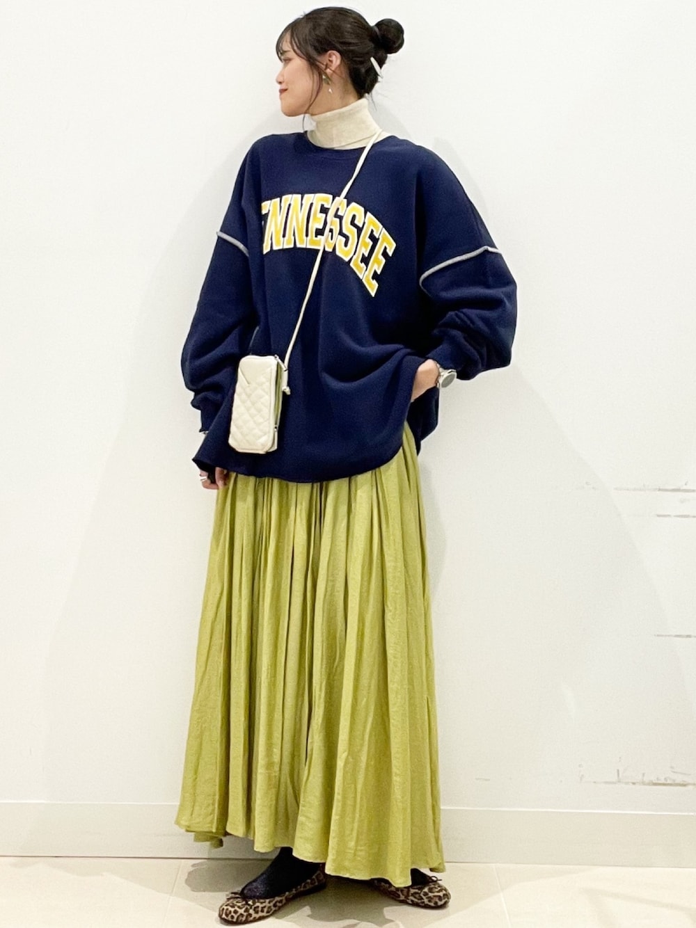 イエロー系のスカートを着用したレディースの冬コーディネートの1枚目の写真