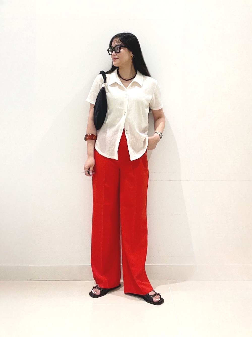 レッド系のその他パンツ、ブラック系のサンダル、ブラック系のハンドバッグを着用したレディースの夏コーディネートの1枚目の写真