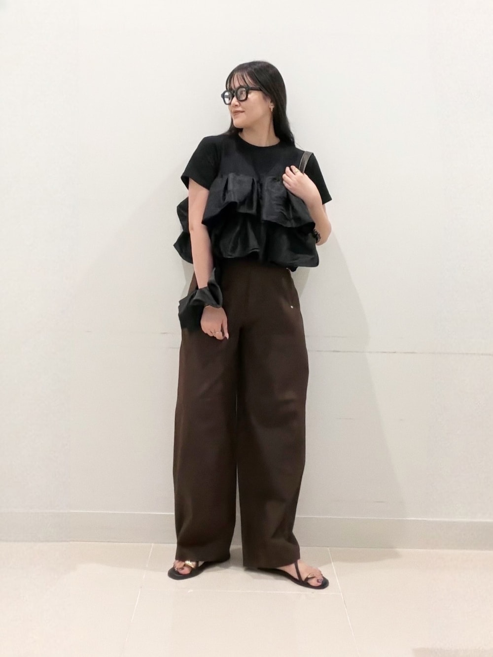 ブラウン系のショルダーバッグ、ブラック系のTシャツ/カットソー、ブラウン系のその他パンツを着用したレディースの夏コーディネートの1枚目の写真