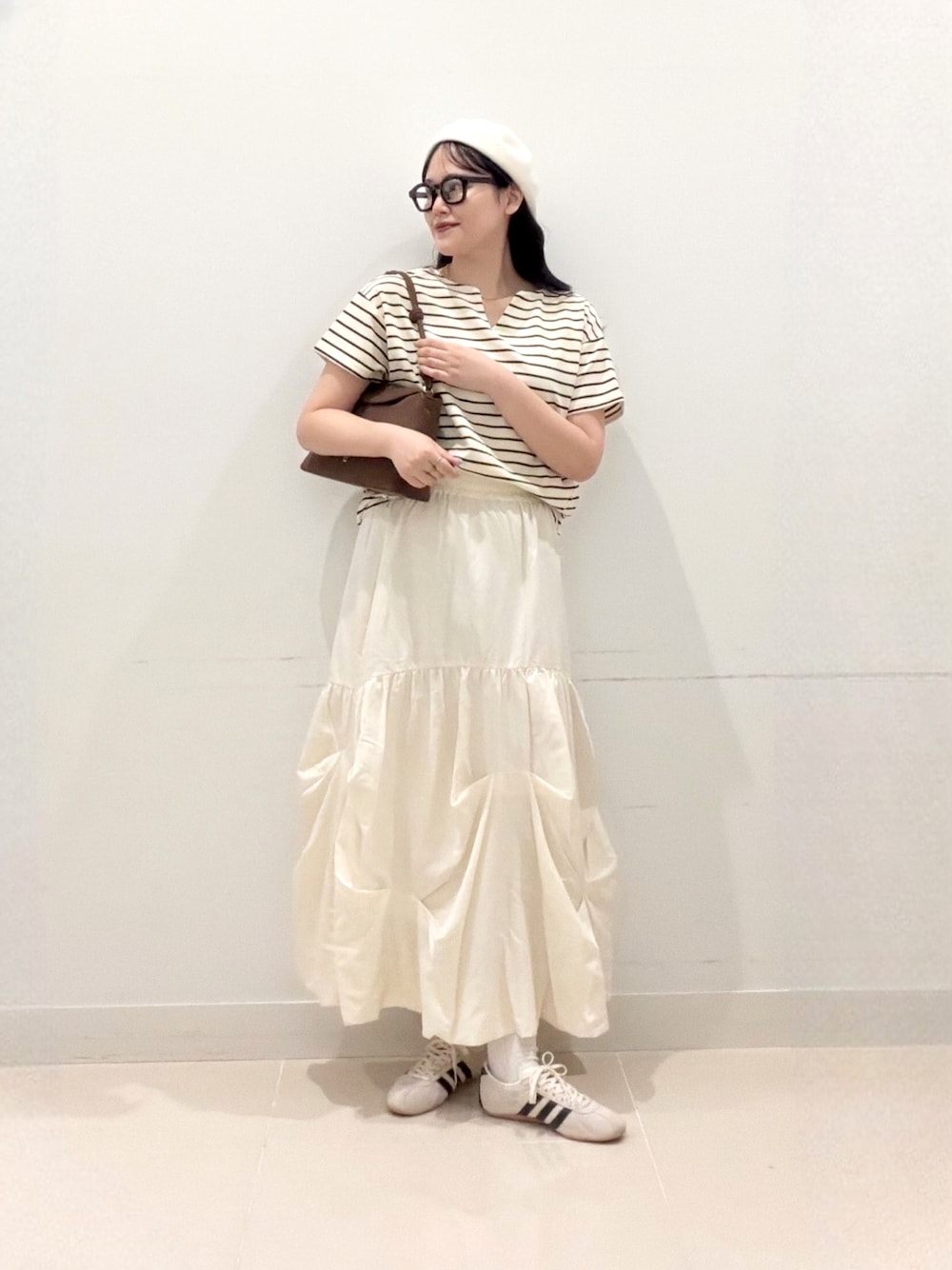ホワイト系のTシャツ/カットソー、ホワイト系のスカート、ホワイト系のスニーカーを着用したレディースの夏コーディネートの1枚目の写真