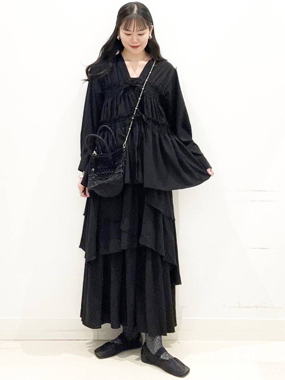 ブラック系のショルダーバッグ、ブラック系のキャミソール、ブラック系のパンプスを着用したレディースの春コーディネートの1枚目の写真