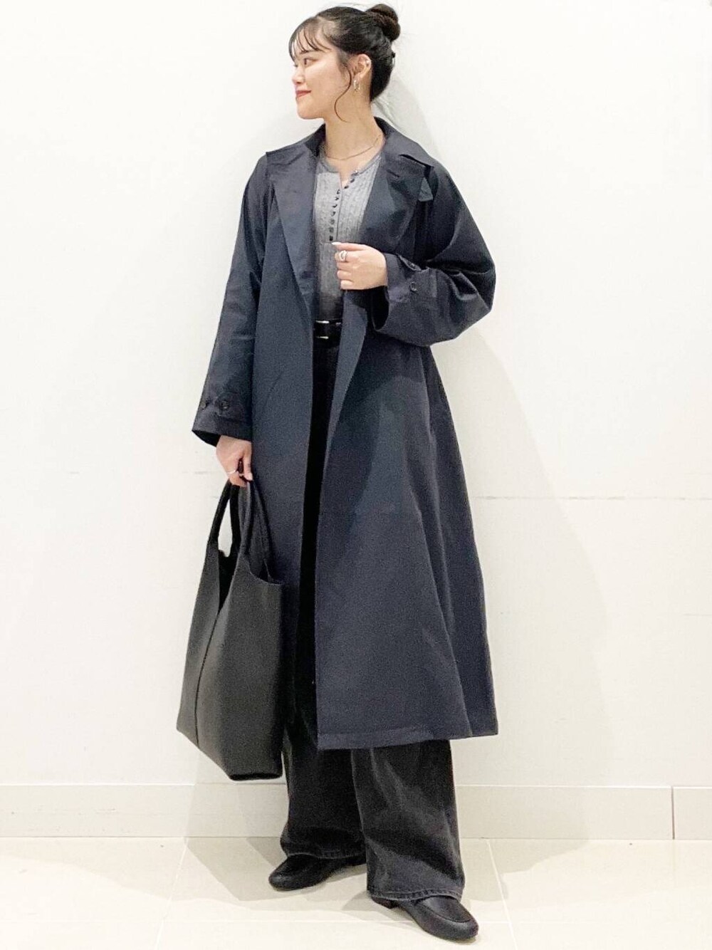 ブラック系のデニムパンツ、グレー系のニット/セーター、ブラック系のローファーを着用したレディースの春コーディネートの1枚目の写真