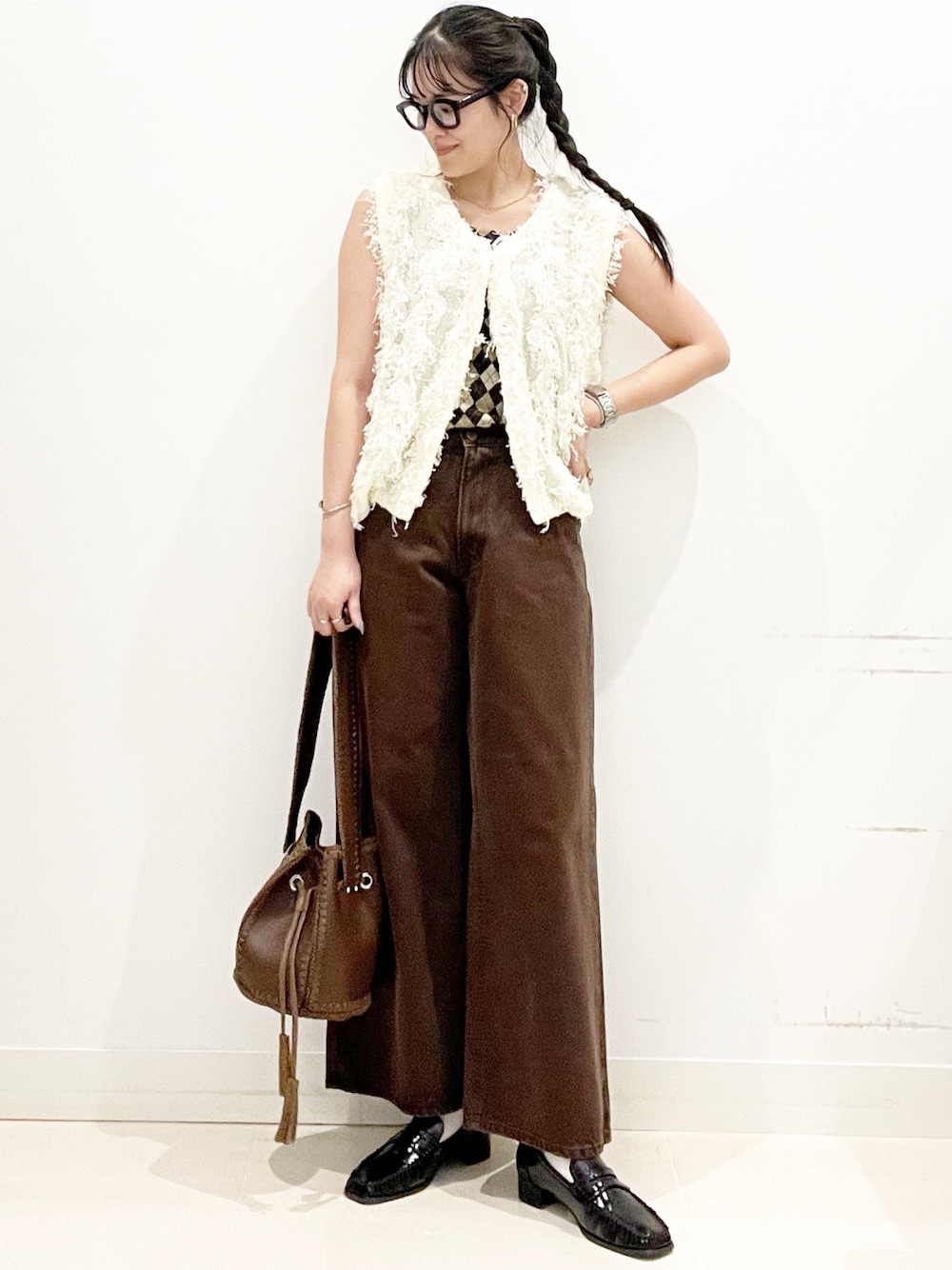 ブラック系のローファー、ブラウン系のショルダーバッグ、ブラウン系のデニムパンツを着用したレディースの夏コーディネートの1枚目の写真