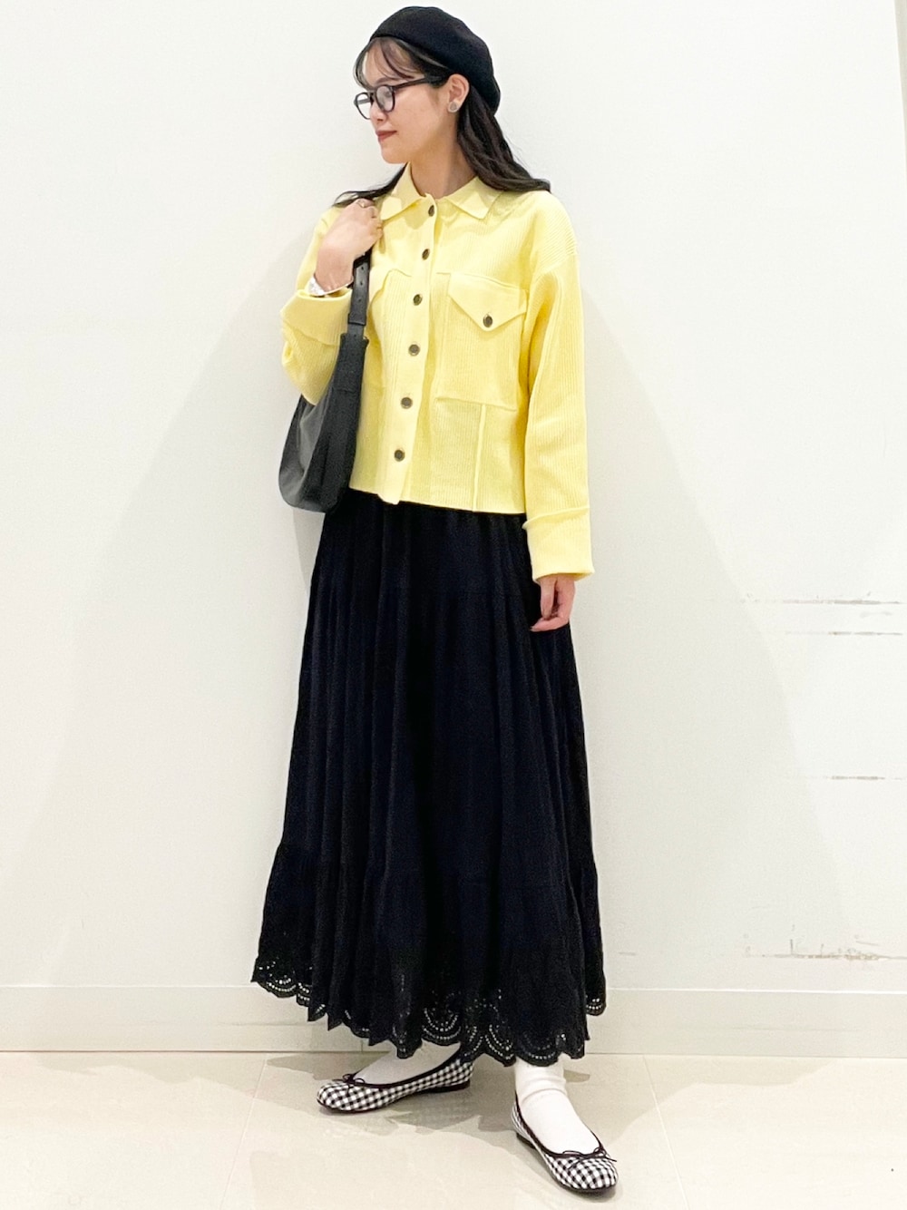 イエロー系のその他アウター、ブラック系のスカートを着用したレディースの冬コーディネートの1枚目の写真