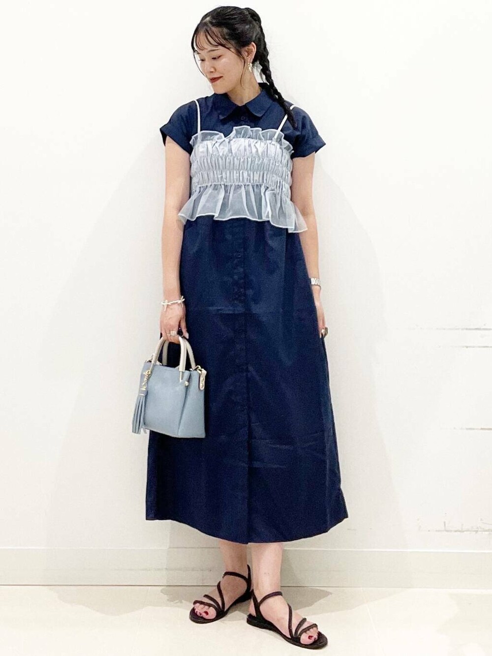 ブルー系のトートバッグ、ブラック系のサンダル、ブルー系のワンピースを着用したレディースの夏コーディネートの1枚目の写真