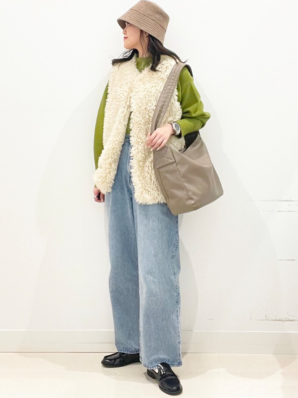 ブラウン系のショルダーバッグを着用したレディースの冬コーディネートの1枚目の写真