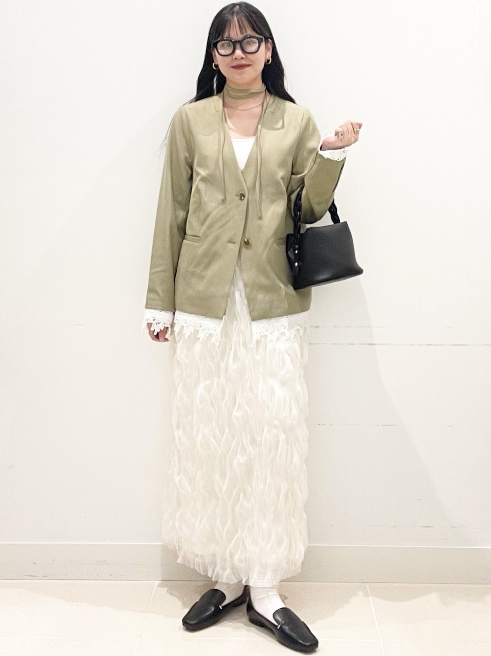 ブラック系のローファー、ホワイト系のスカート、ベージュ系のノーカラージャケットを着用したレディースの春コーディネートの1枚目の写真