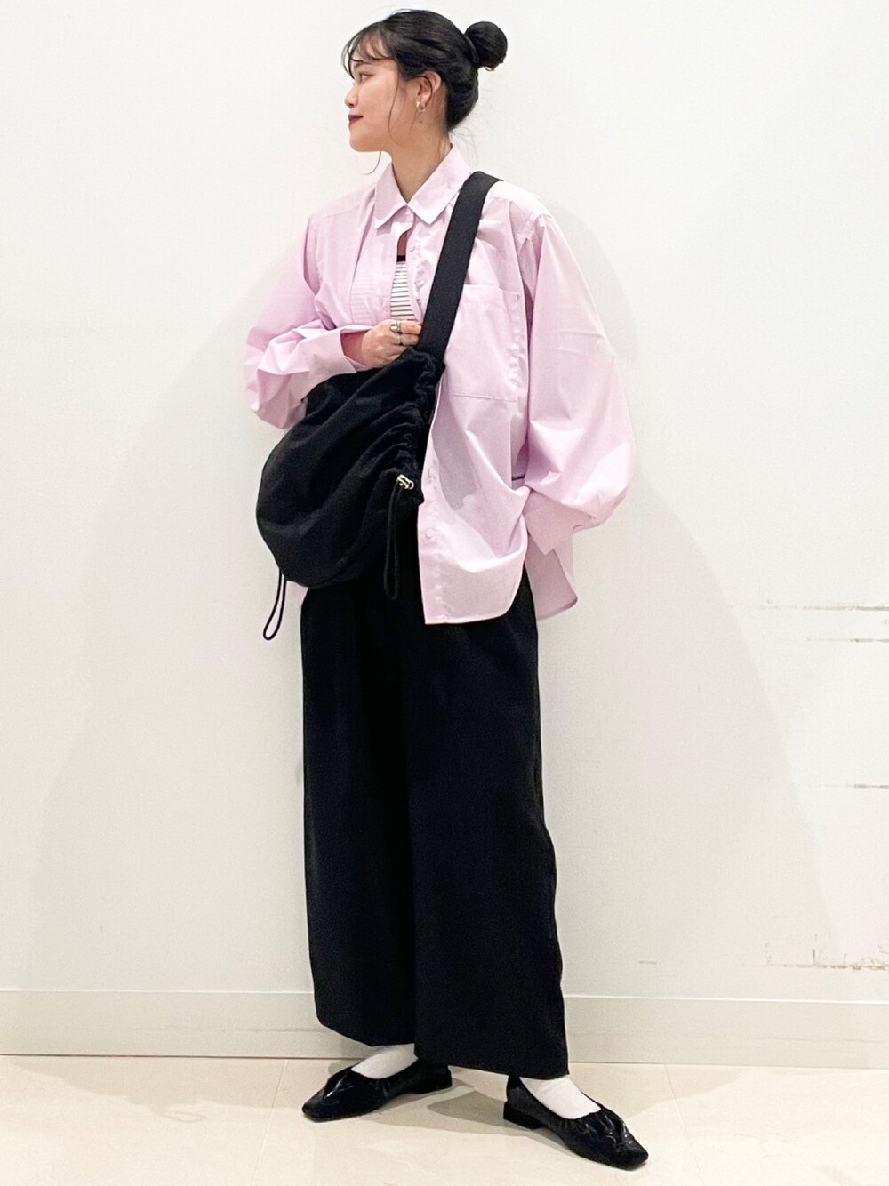 ピンク系のシャツ/ブラウス、ブラック系のパンプス、ブラック系のショルダーバッグを着用したレディースの冬コーディネートの1枚目の写真