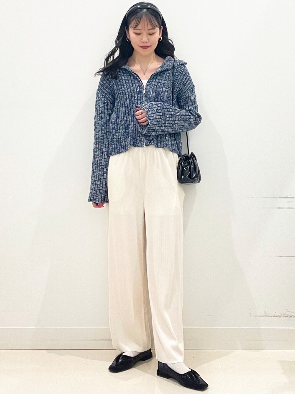 ホワイト系のキャミソール、ブルー系のニット/セーター、ブラック系のショルダーバッグを着用したレディースの冬コーディネートの1枚目の写真