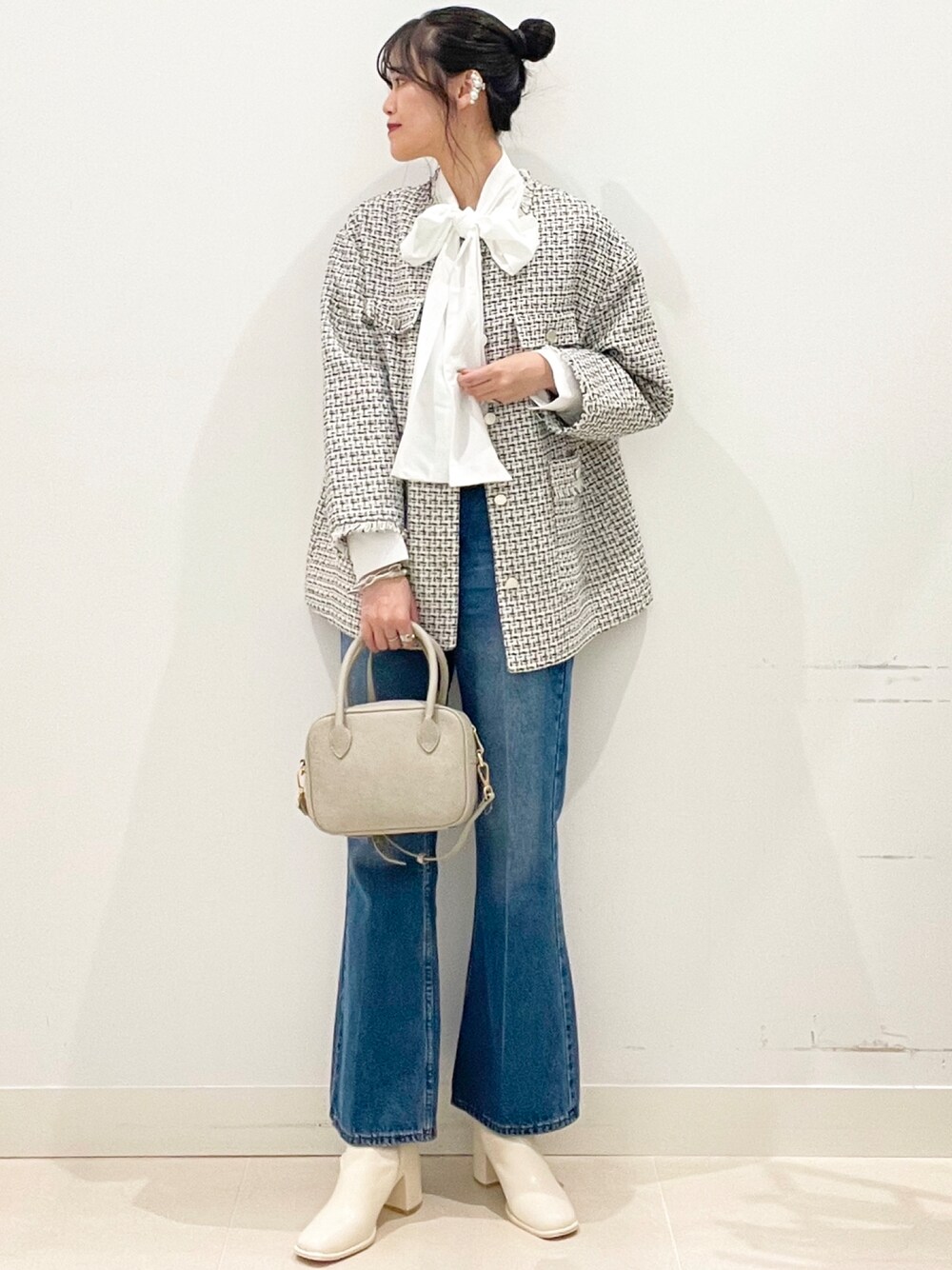ブルー系のデニムパンツ、ホワイト系のブーツを着用したレディースの冬コーディネートの1枚目の写真
